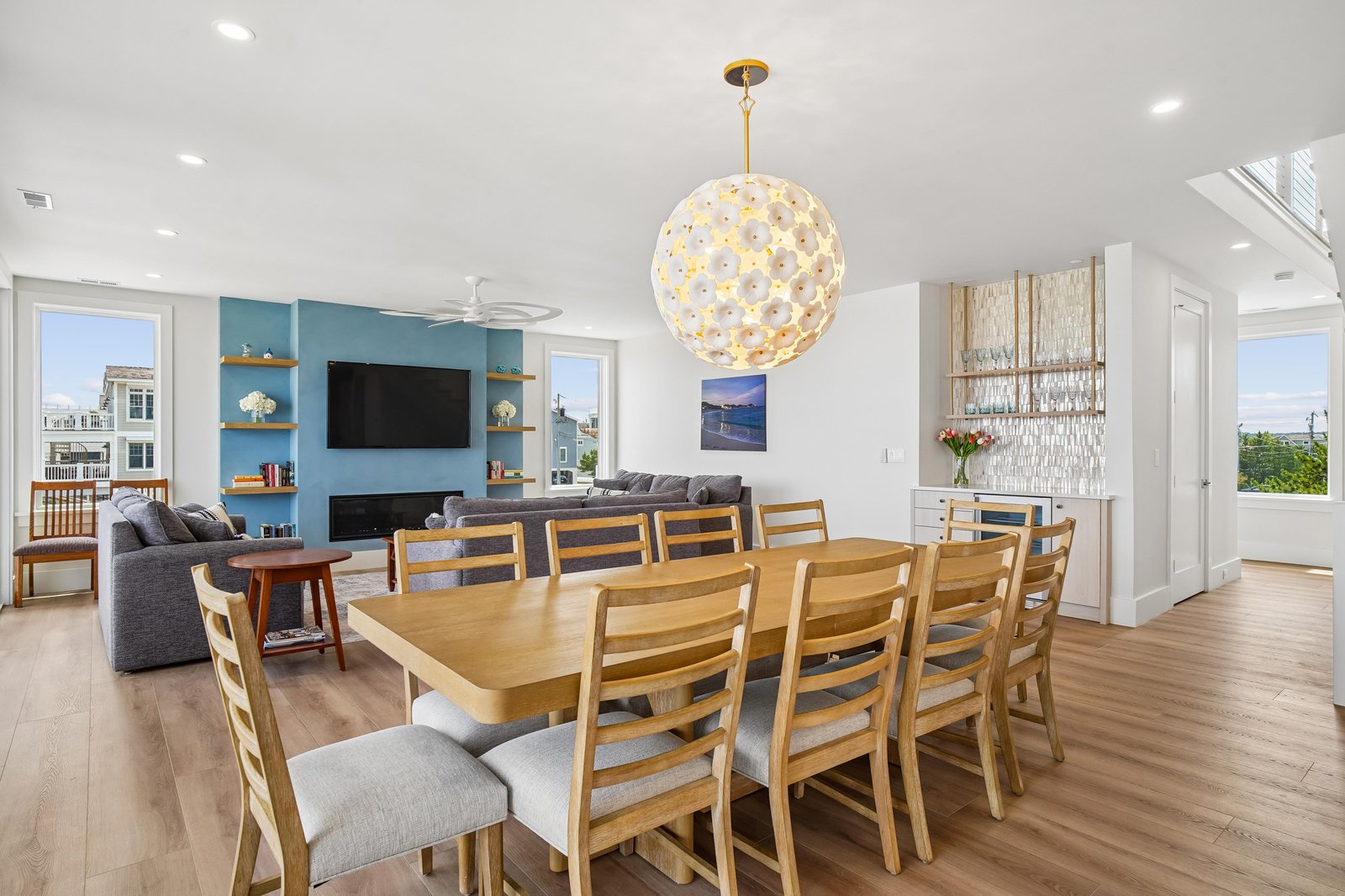 Step into this sun-drenched open-plan living space where your entire group can gather around the grand dining table, relax in the cozy lounge, or unwind by the modern fireplace under the stunning statement chandelier.
