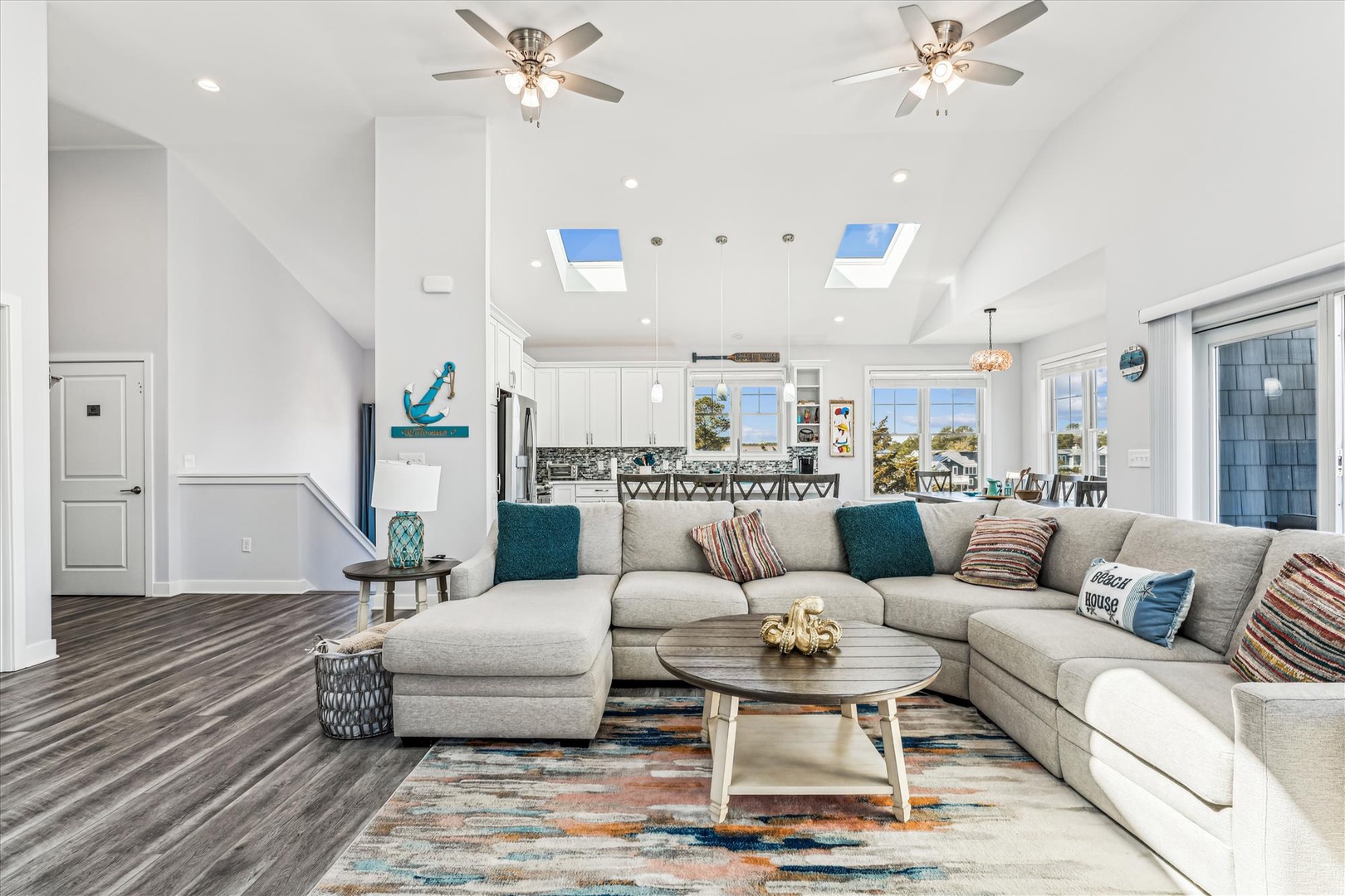 Your spacious living room features soaring ceilings, skylights, and cozy sectional seating perfect for relaxing after beach adventures.