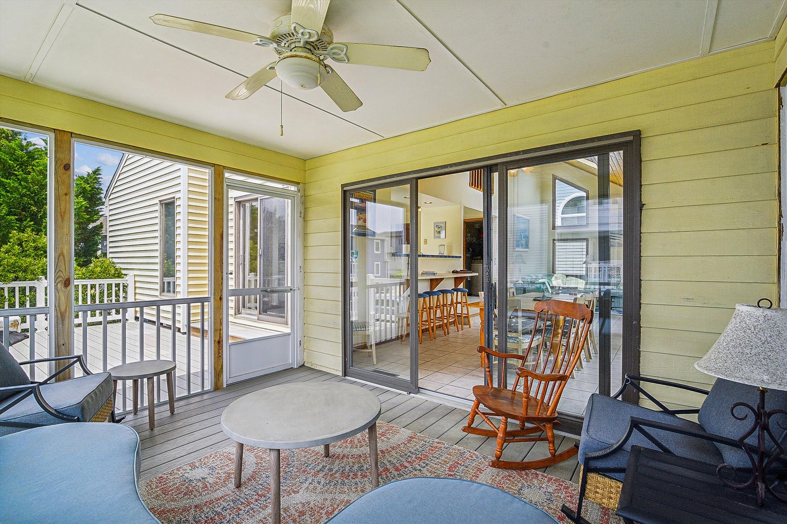 Your private screened porch offers a peaceful retreat with ceiling fan, comfortable seating, and gentle views of the surrounding neighborhood—perfect for morning coffee or evening relaxation.