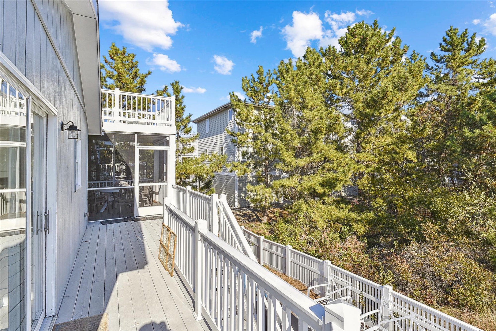 This spacious balcony offers your own private retreat with serene views of lush evergreens and neighboring rooftops, perfect for your morning coffee or sunset unwind.