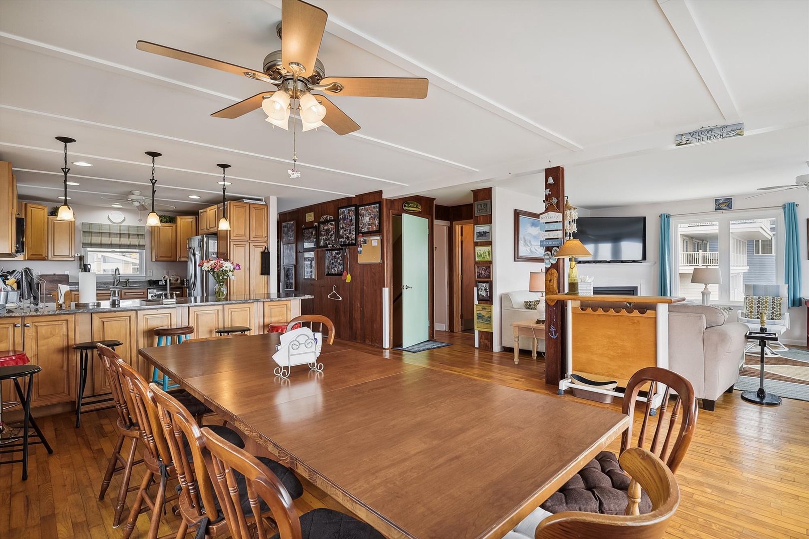 Settle into this inviting open-concept space where your kitchen, dining, and living areas flow together effortlessly. Gather around the large dining table or relax by the cozy sitting area with beautiful hardwood floors beneath your feet.