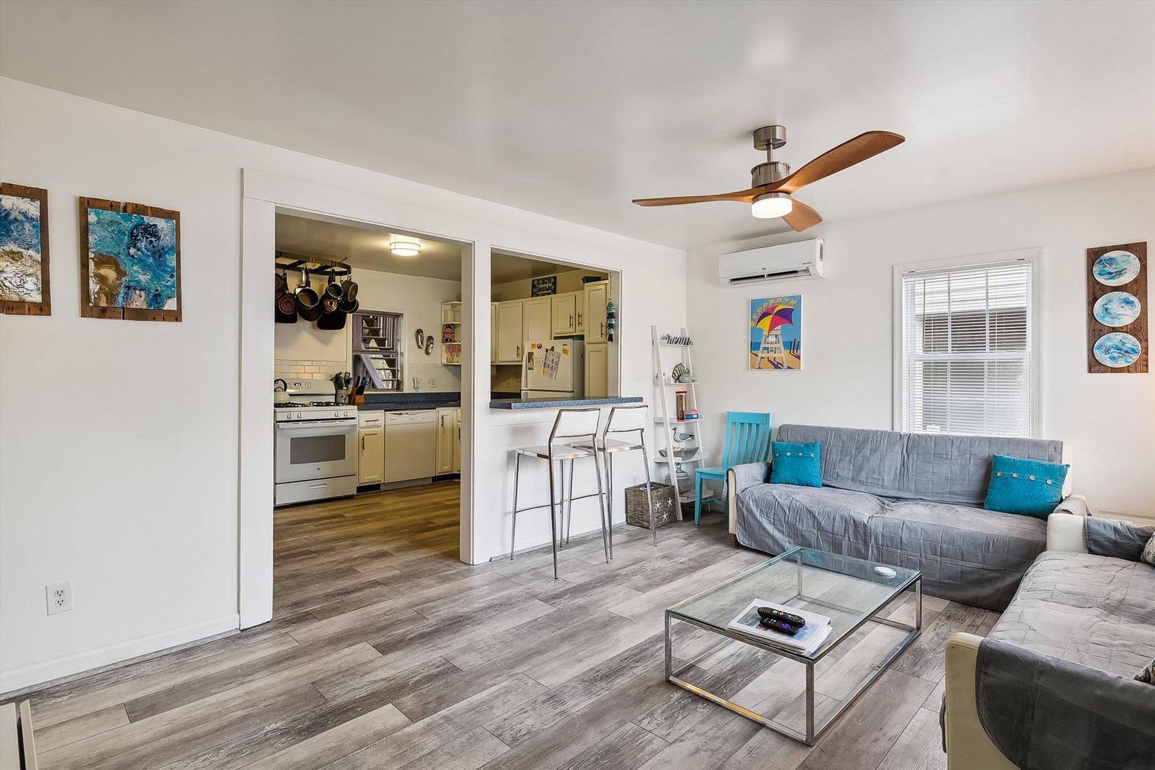 Step into your bright, inviting living space where comfortable seating, colorful coastal art, and modern amenities create the perfect backdrop for memorable vacation moments.