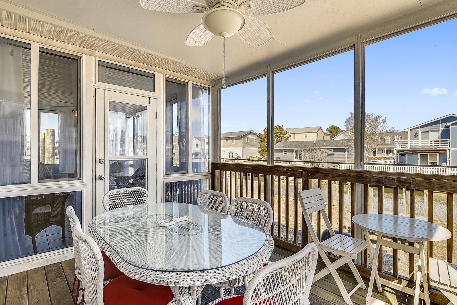 Gather around this screened porch for meals and conversation while enjoying gentle breezes and bright coastal light streaming through the windows.