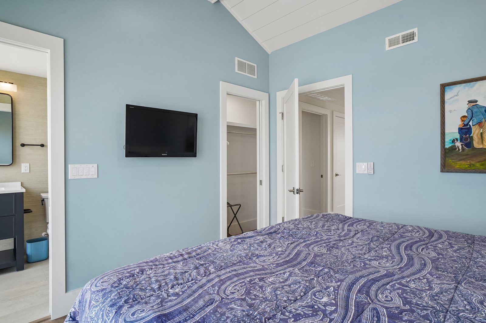 Unwind in your peaceful bedroom with calming coastal colors and vaulted ceilings. Fresh linens await, while your ensuite bathroom adds extra convenience for a truly restful stay.