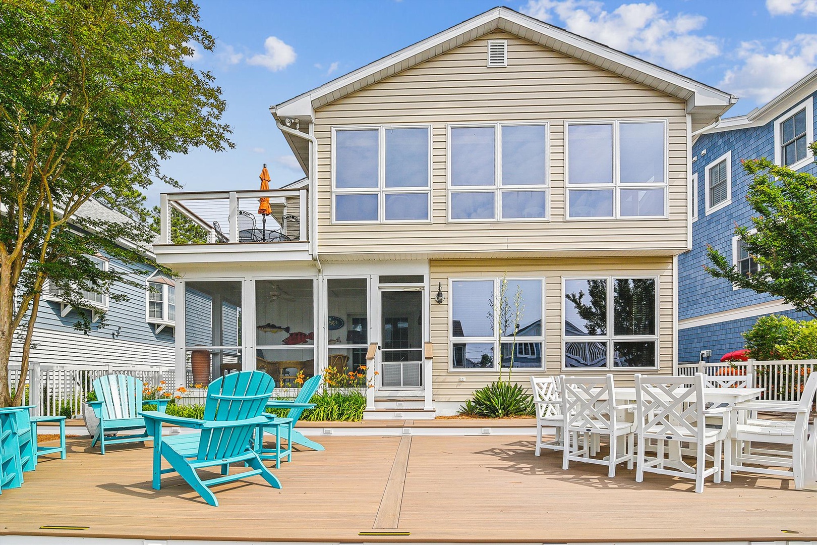 Coastal property featuring a spacious two-story exterior with generous deck areas, outdoor seating, and a private second-floor balcony—perfect for seaside relaxation.