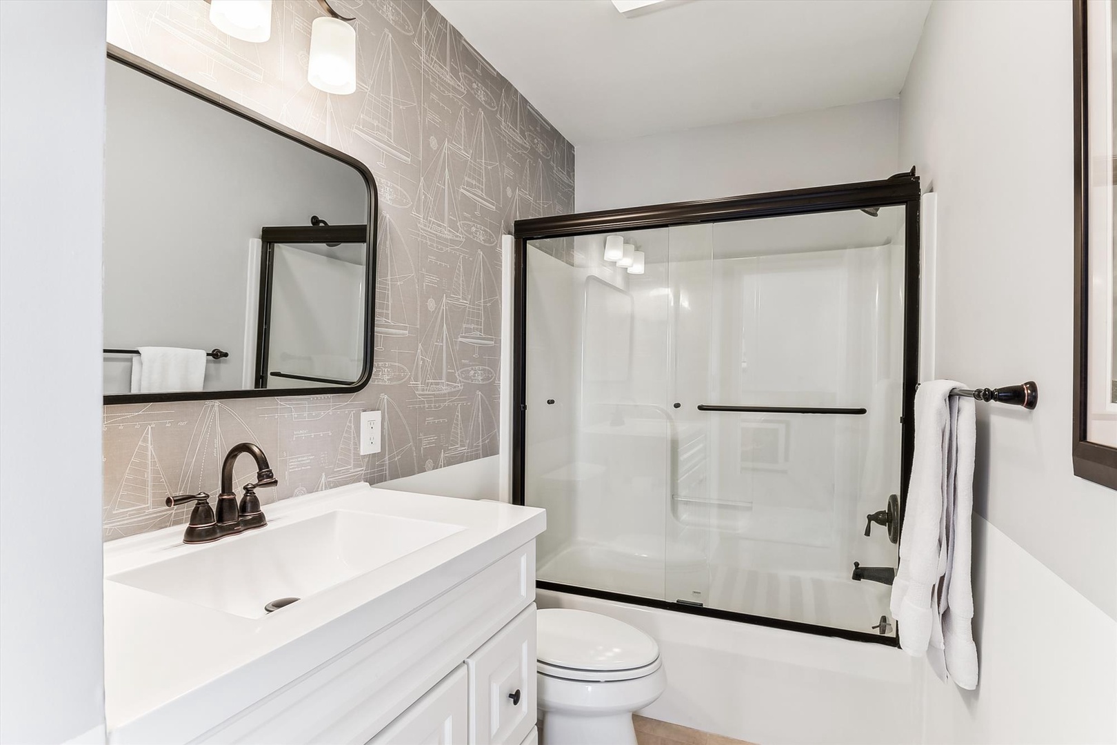 Step into your sleek, modern bathroom with a spacious walk-in shower, elegant fixtures, and nautical-inspired tile—a refreshing retreat after a day of adventure.