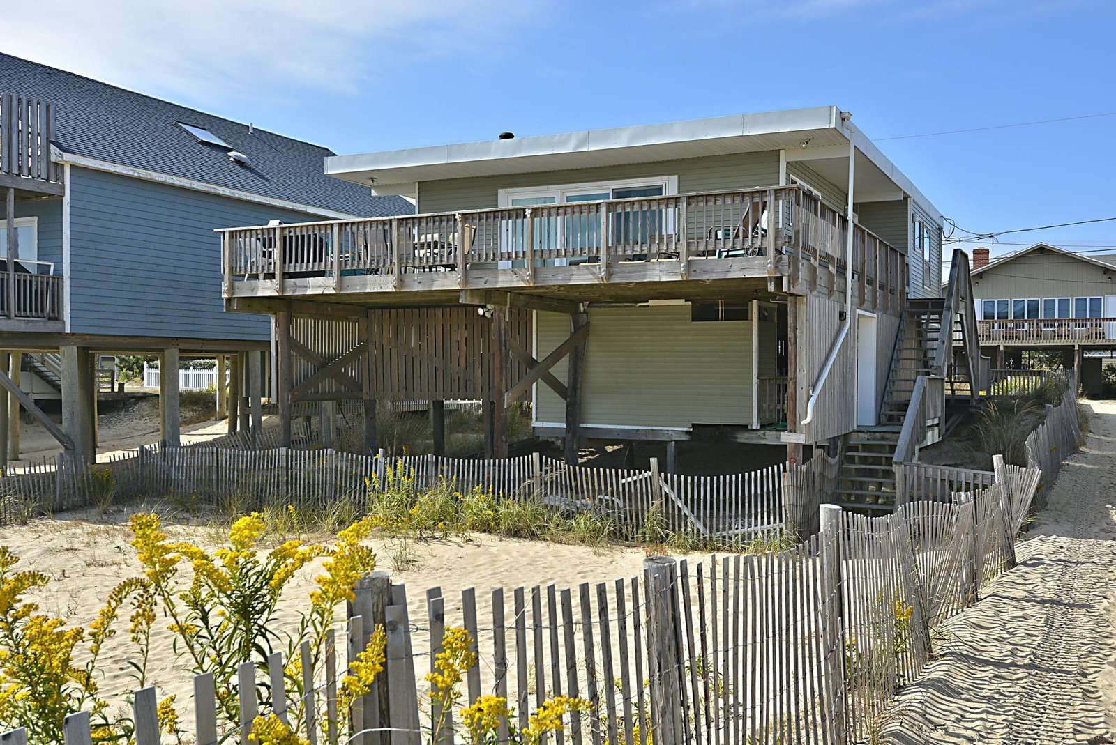 This beachfront property is perched on stilts with direct beach access just beyond the dunes. The elevated deck offers sweeping ocean views, perfect for sunrise coffee or sunset relaxation.