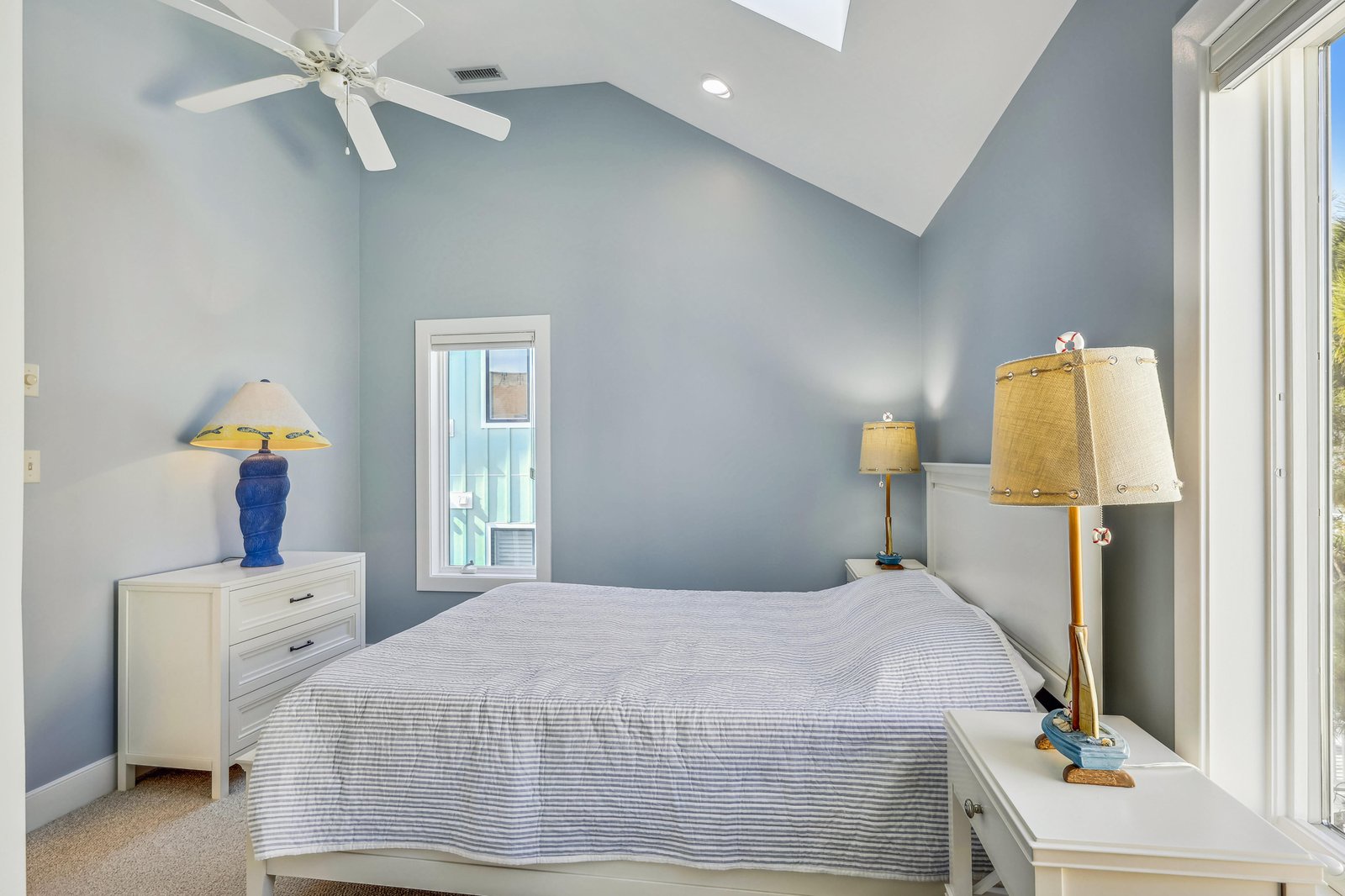 Unwind in your peaceful retreat with vaulted ceilings and soft coastal tones. The airy room features a cozy queen bed, gentle lighting, and a calming atmosphere perfect for restful nights.