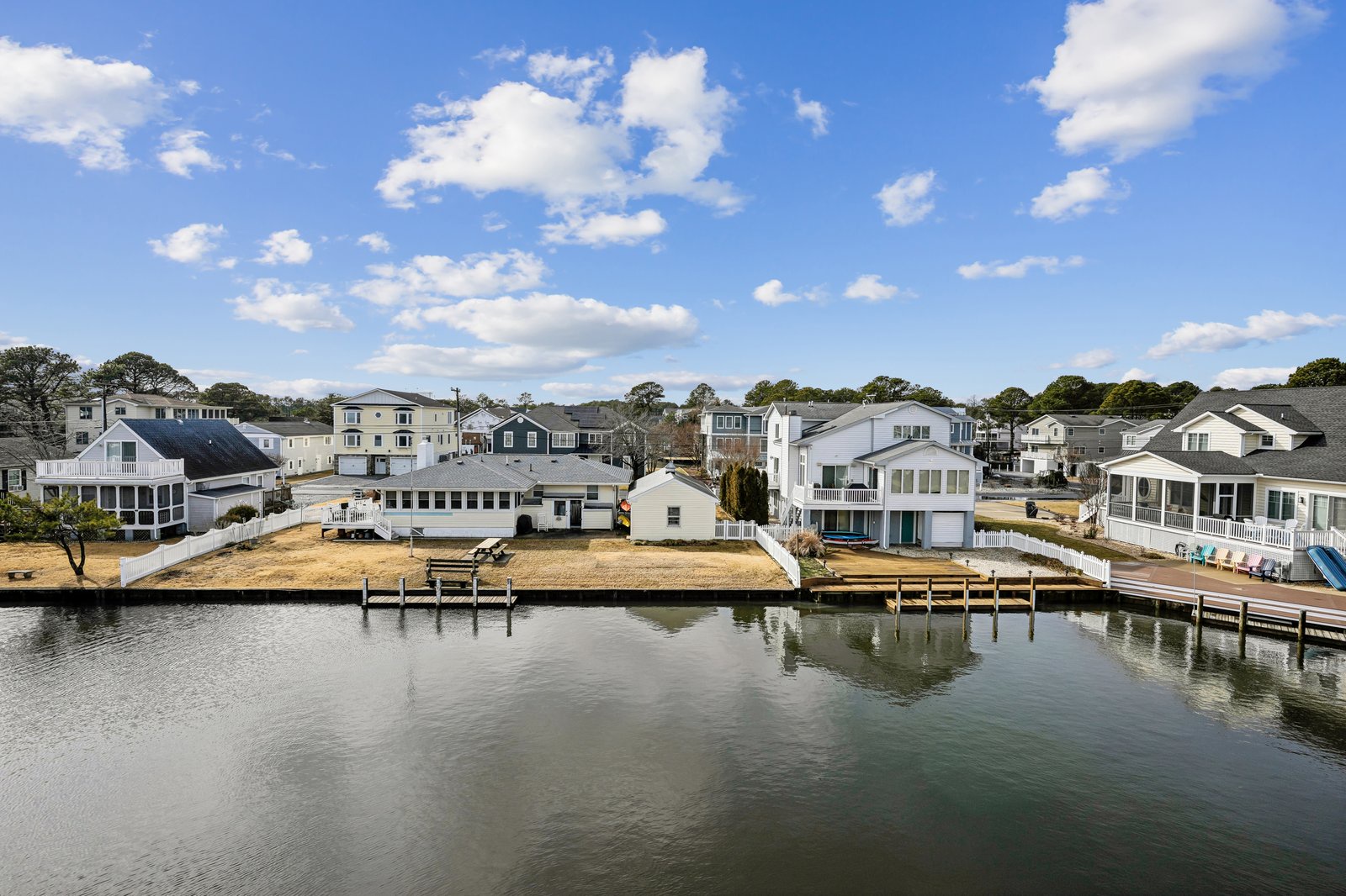 Waterfront community featuring canal-side homes with private docks and boat access under a perfect blue sky.