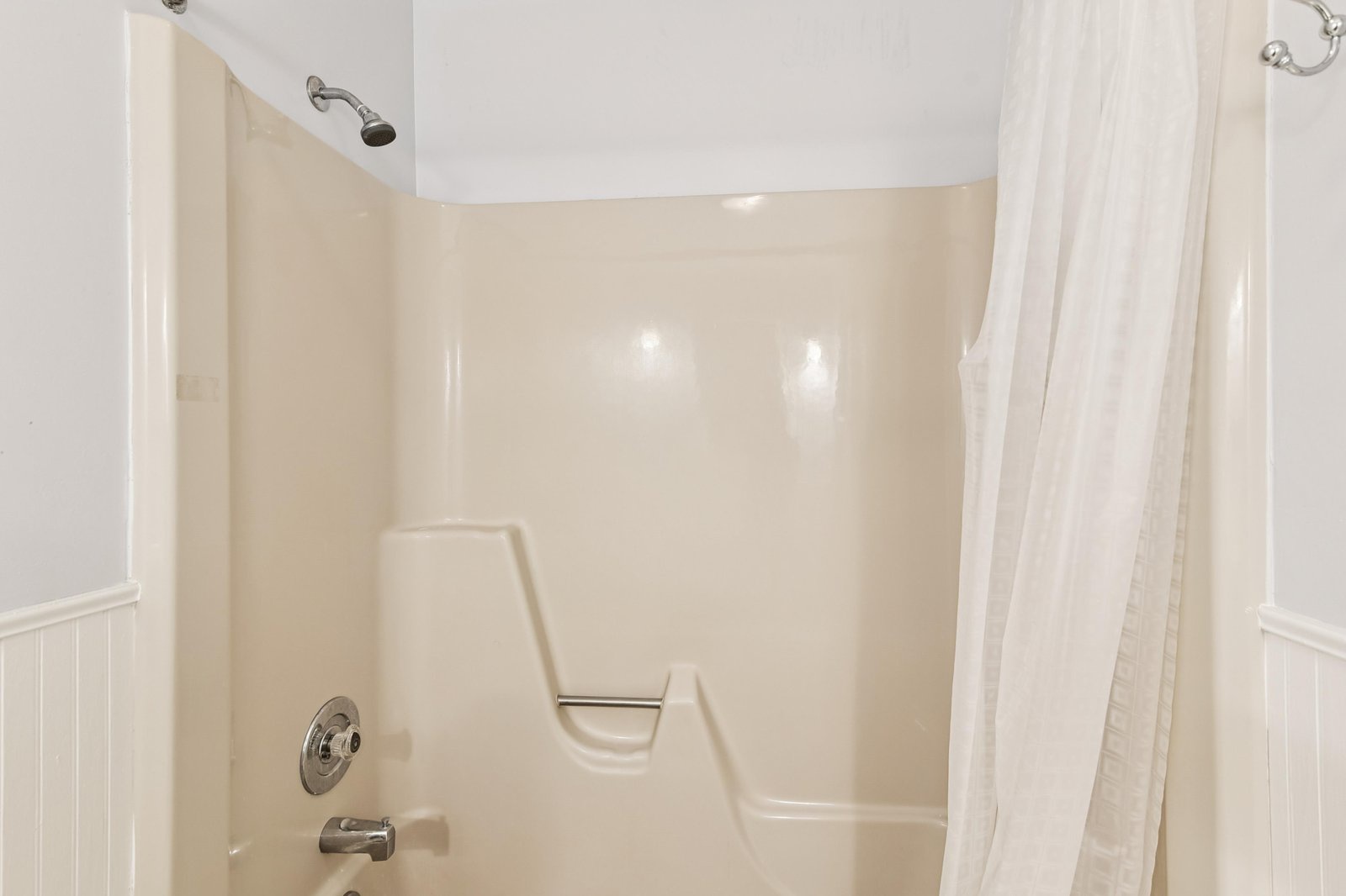 This spotless tub and shower combo features a sturdy grab bar for your safety, plus fresh white tile surround and a crisp new curtain. Bright, accessible, and ready for a refreshing rinse after your day's adventures.