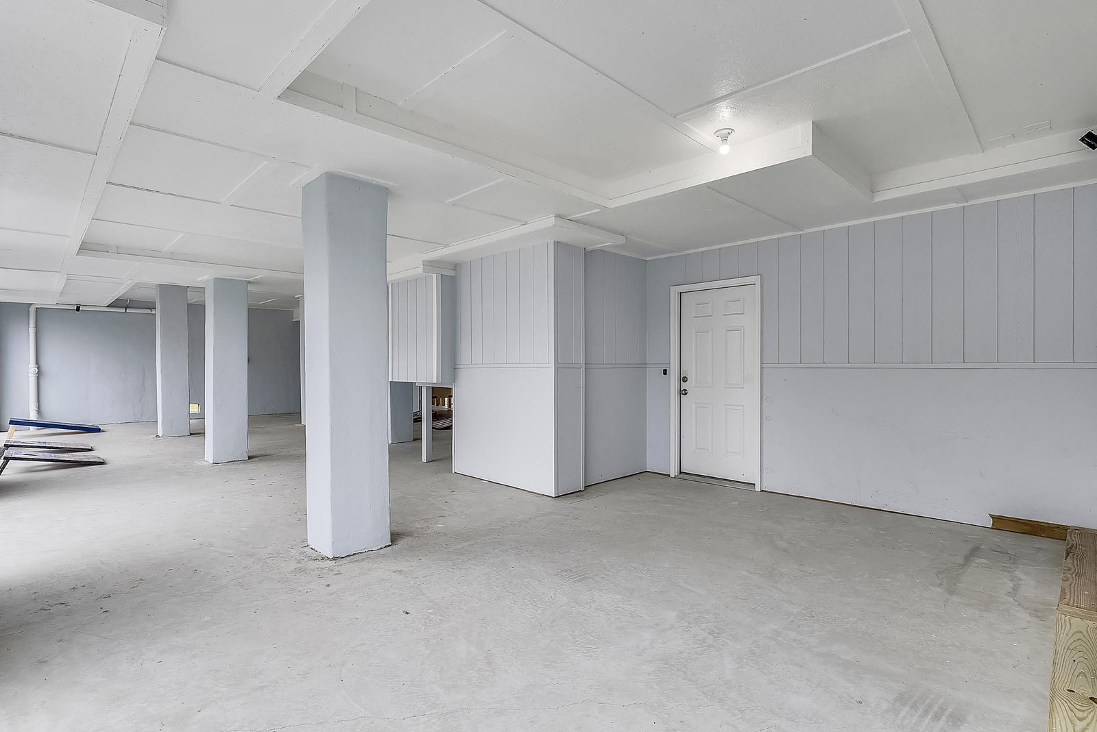 The property includes a spacious finished basement area with painted walls and columns, offering flexible storage or recreational space for your group.