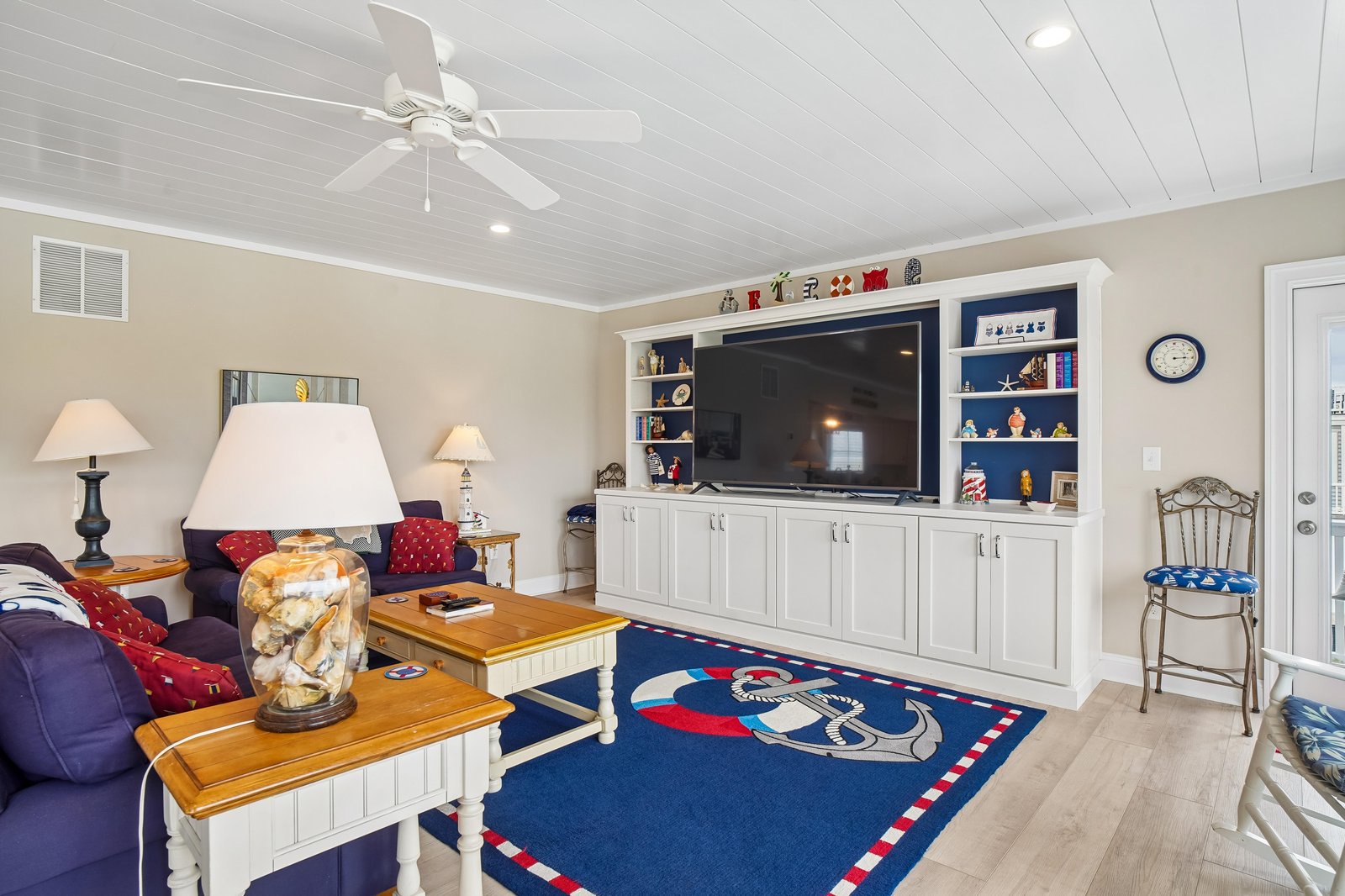 Settle in with your favorite movie on the spacious sofa while a gentle breeze from the ceiling fan keeps you comfortable in this cozy coastal-inspired living room.