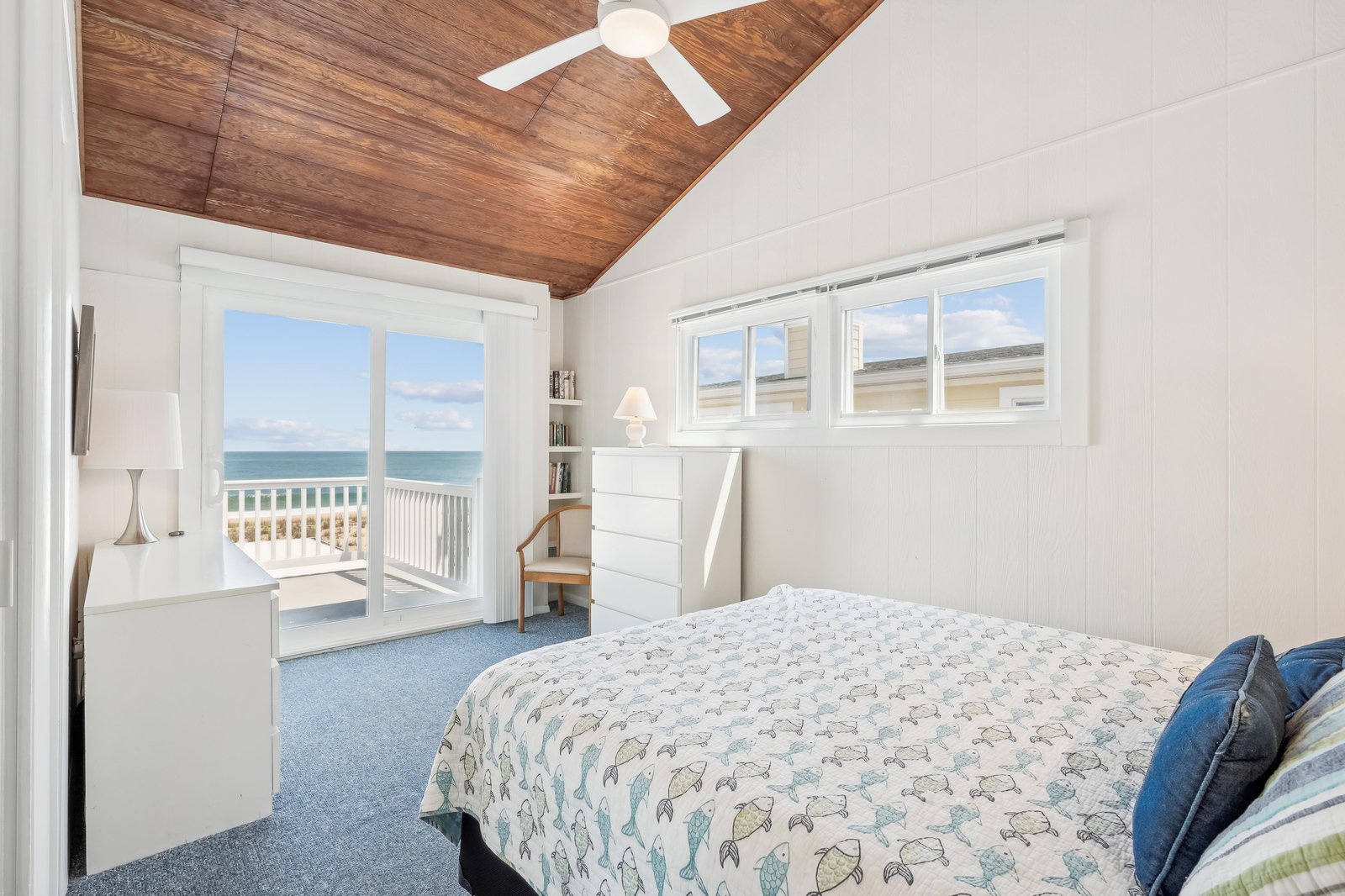 Your bright bedroom features a vaulted wood ceiling, French doors opening onto a private balcony, and stunning ocean views—wake each morning to the sound of waves and the sight of endless blue horizons.