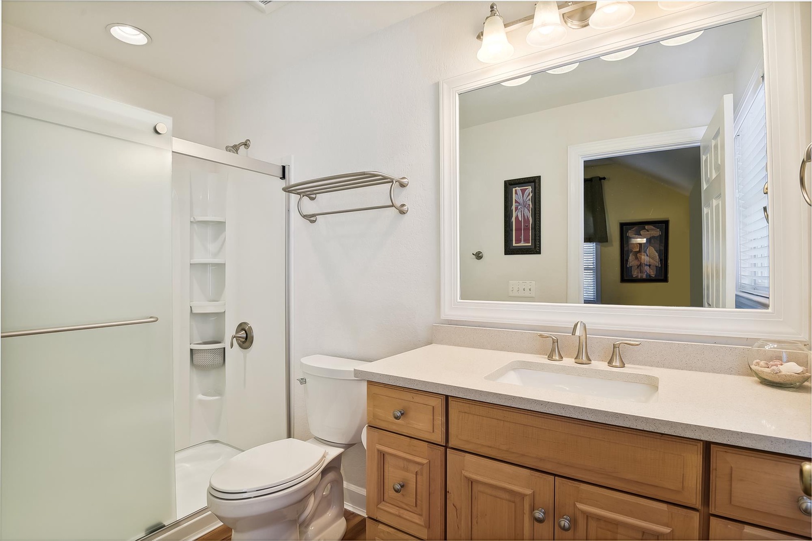 Step into your pristine bathroom featuring warm wood vanity, spacious shower, and elegant touches for your comfort.