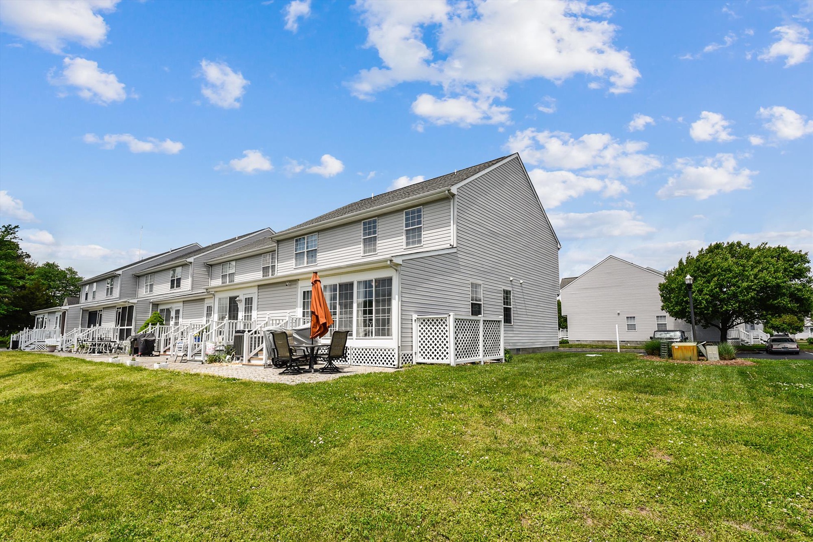 This townhome-style property is located in a quiet residential neighborhood with spacious green lawns and convenient outdoor living areas.