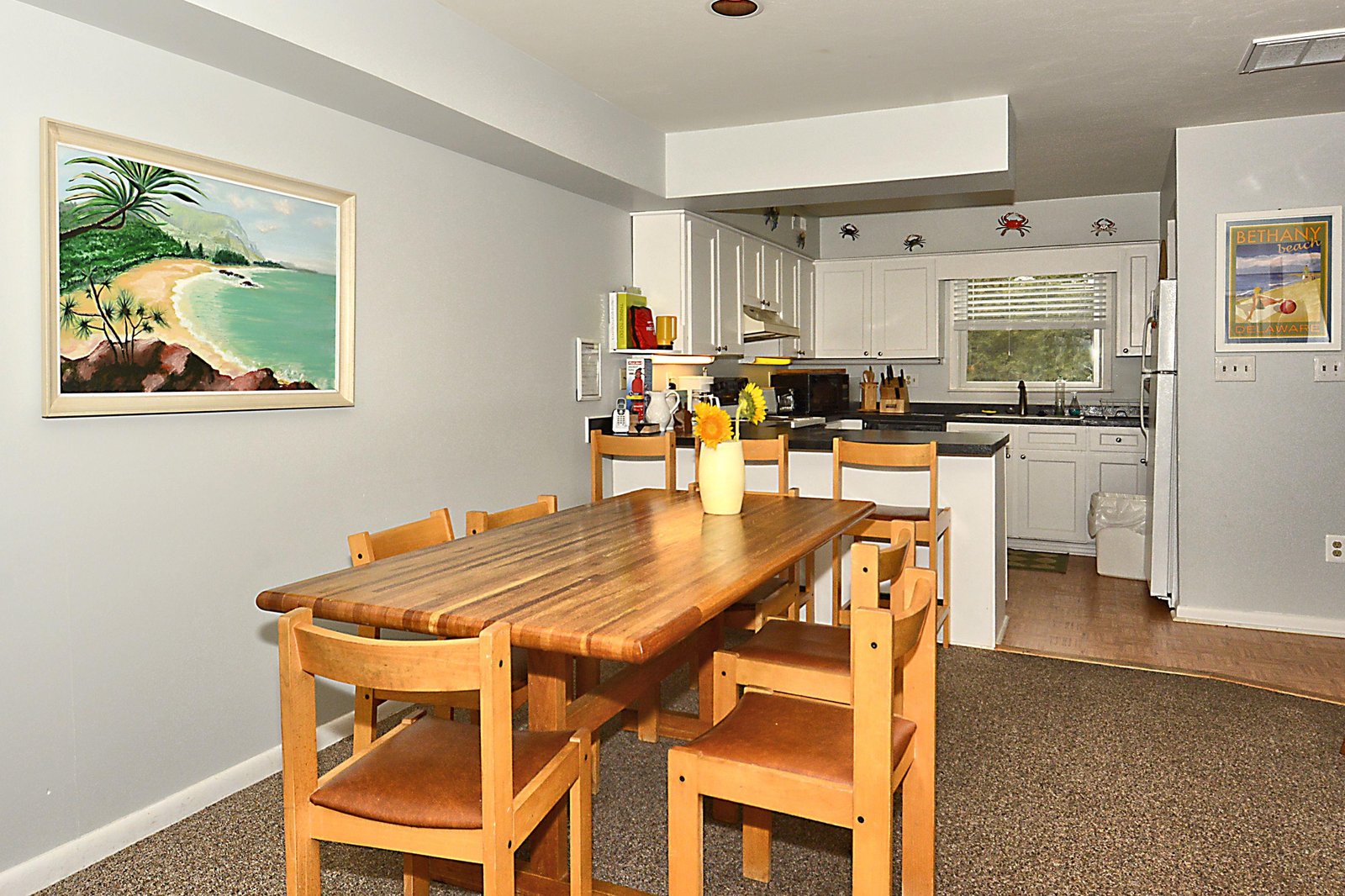 Gather around the warm wooden table for a meal in this inviting dining area, opening directly into your fully-equipped kitchen where all your vacation cooking needs are met.