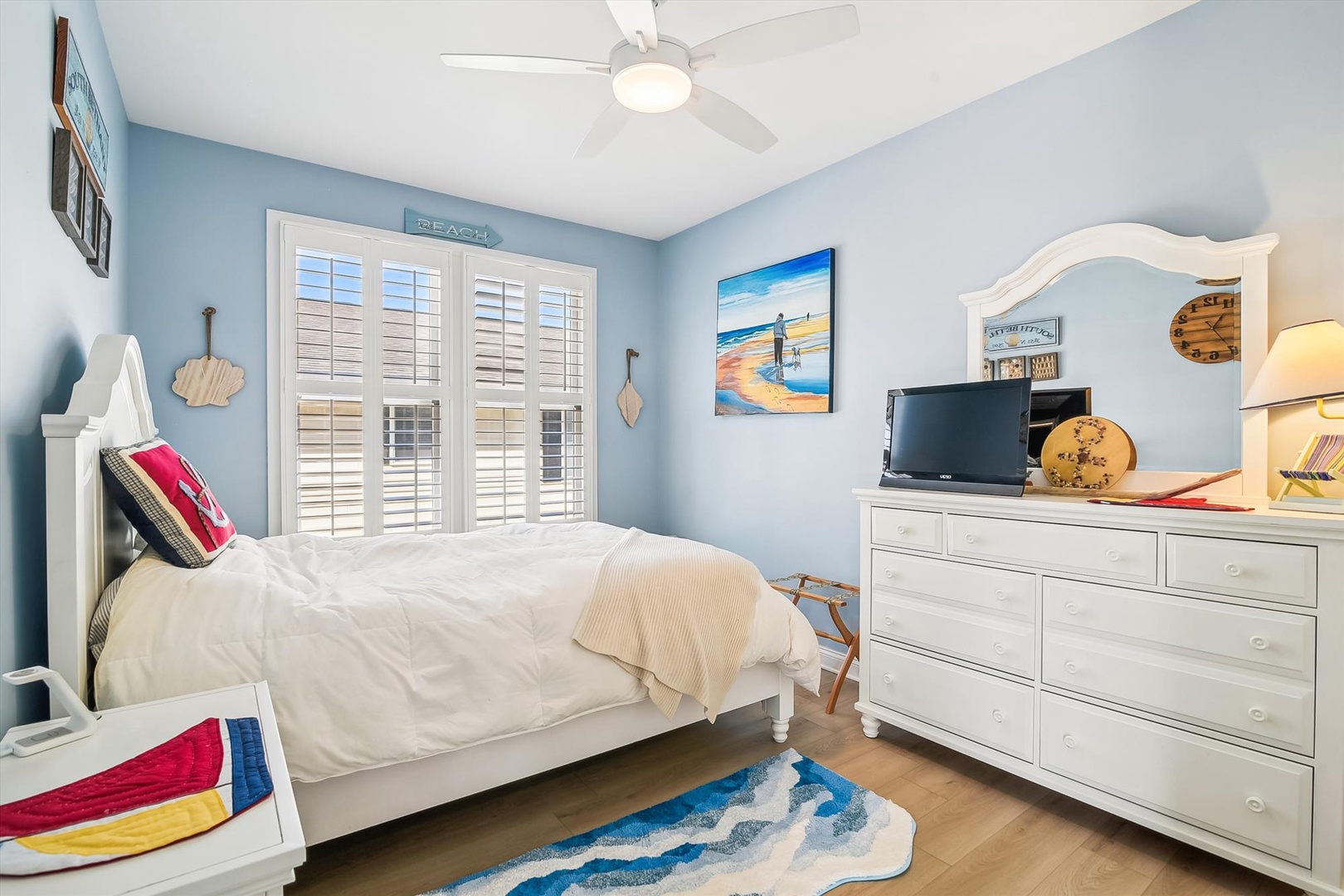Drift off to sleep in this coastal-inspired bedroom with cheerful beach decor, a ceiling fan for your comfort, and a flat-screen TV for leisurely evenings in.