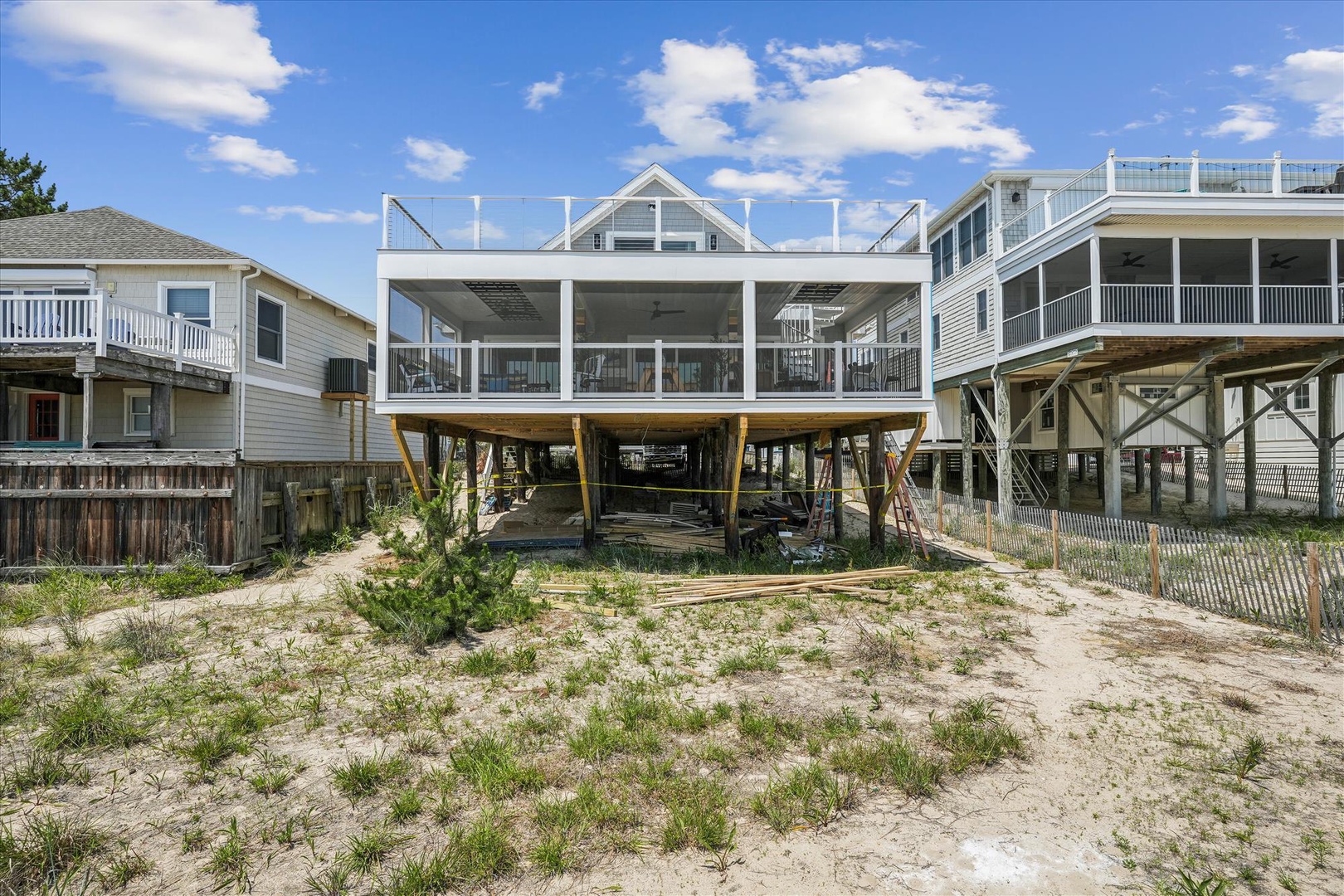 Beachfront home elevated on sturdy stilts, offering direct sandy beach access and coastal views from a spacious wrap-around deck in a quiet residential setting.