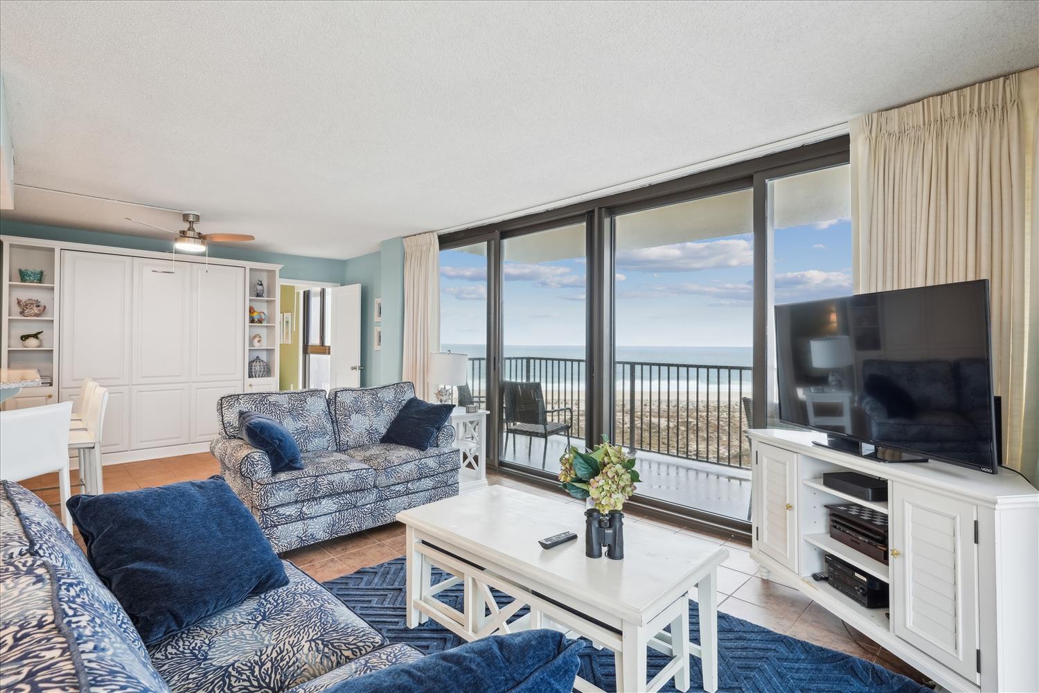 Sink into plush coastal-style sofas and gaze at your private ocean view through floor-to-ceiling windows—your perfect seaside escape awaits with style and comfort.