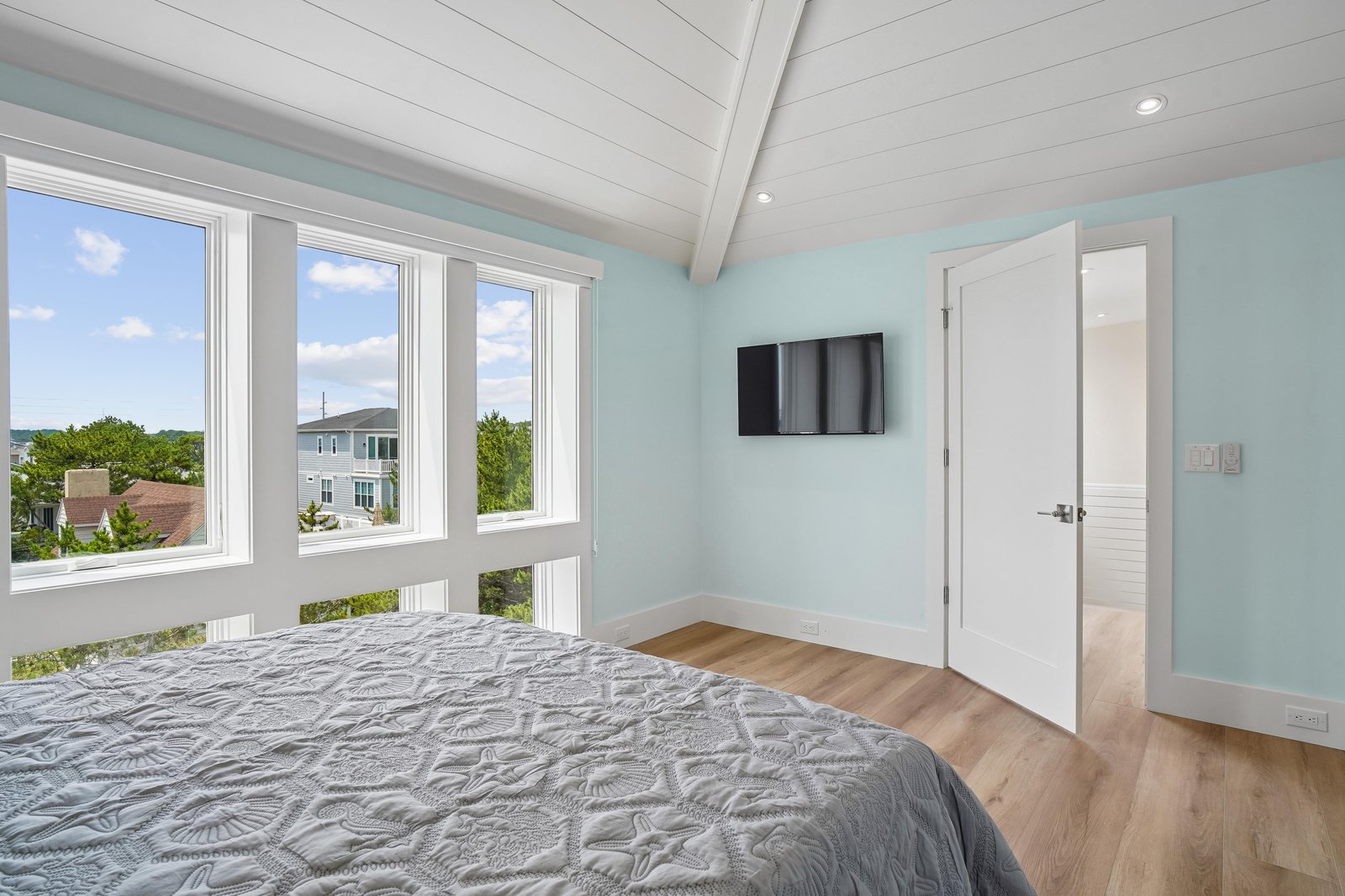 Wake up to sunshine streaming through tall windows framing peaceful neighborhood views. Your serene retreat features vaulted ceilings and soft coastal colors for a refreshing escape.