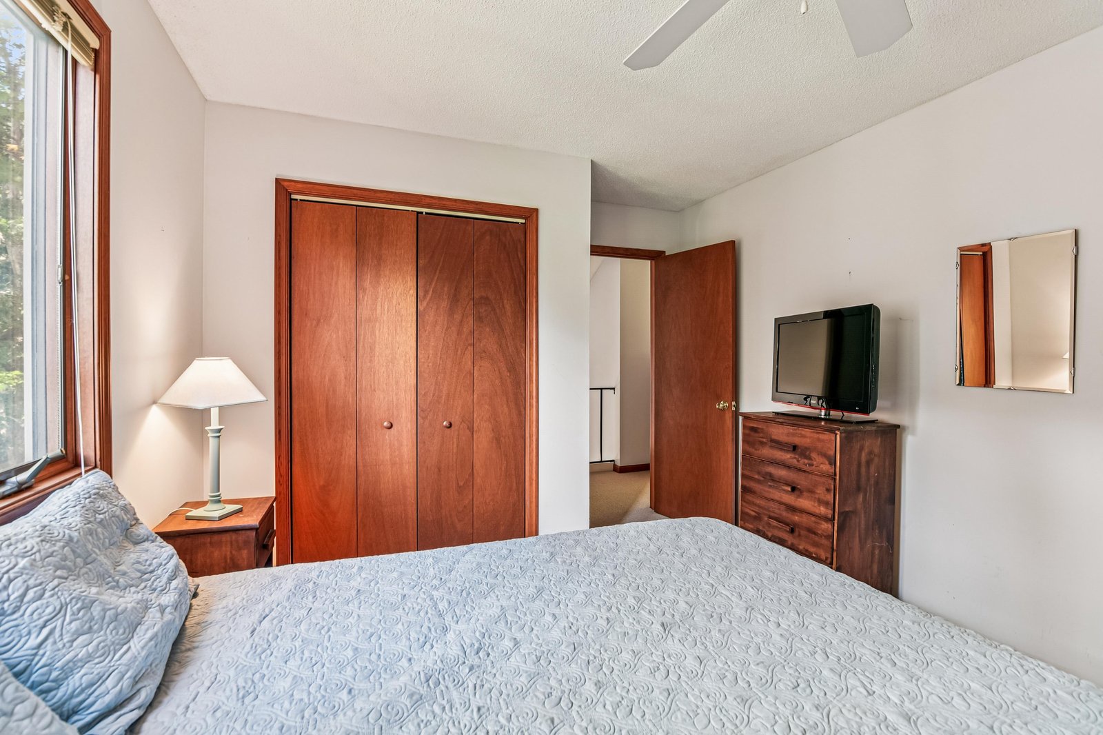 Settle into your peaceful bedroom, where warm wood tones and soft natural light create a restful retreat perfect for unwinding after a day of exploration.
