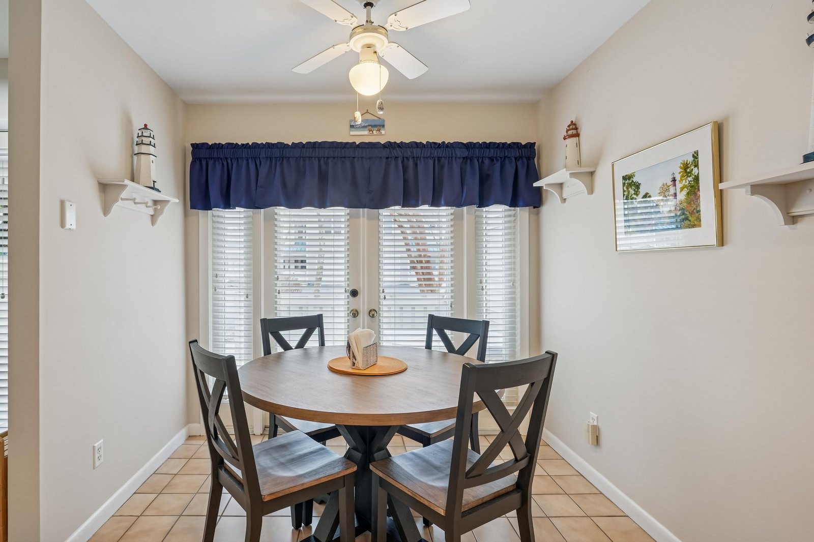 Share laughter and meals at the nautical-themed dining table, with charming lighthouse accents and soft natural light streaming through coastal curtains.