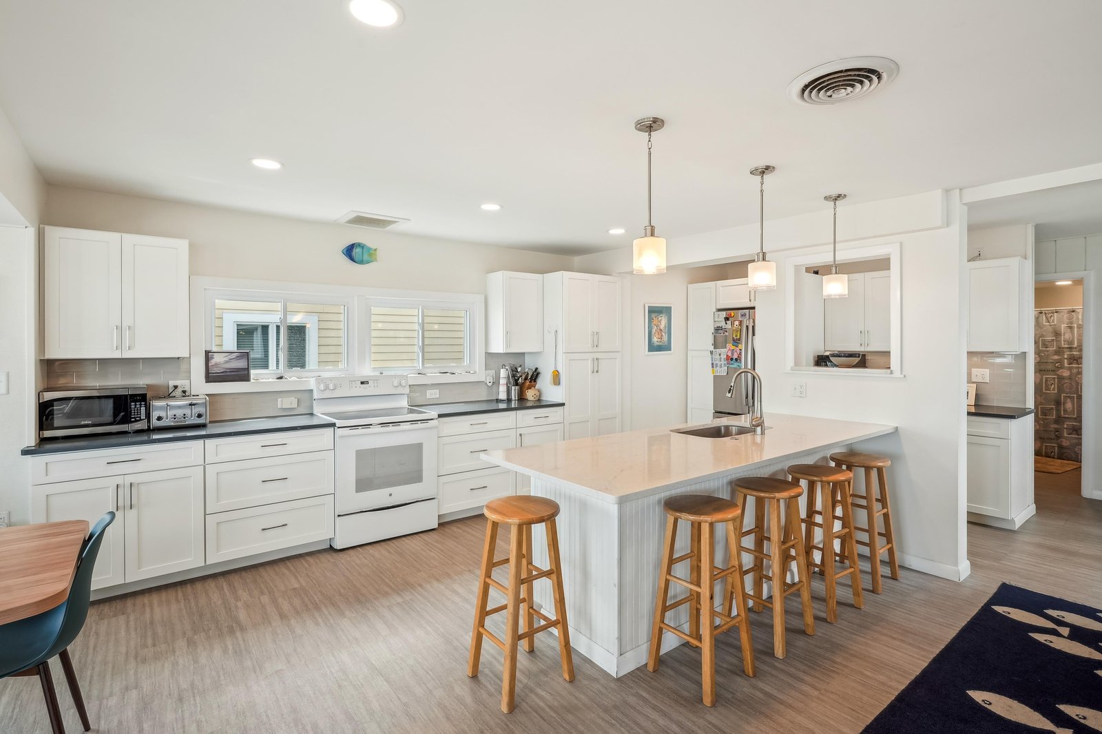 Your spacious kitchen welcomes you with a bright center island perfect for gathering, crisp white cabinetry, modern appliances, and coastal charm throughout.