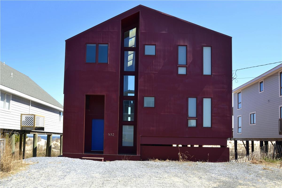 A contemporary beachside property with bold architectural design, nestled in a quiet coastal neighborhood just steps from the shore.