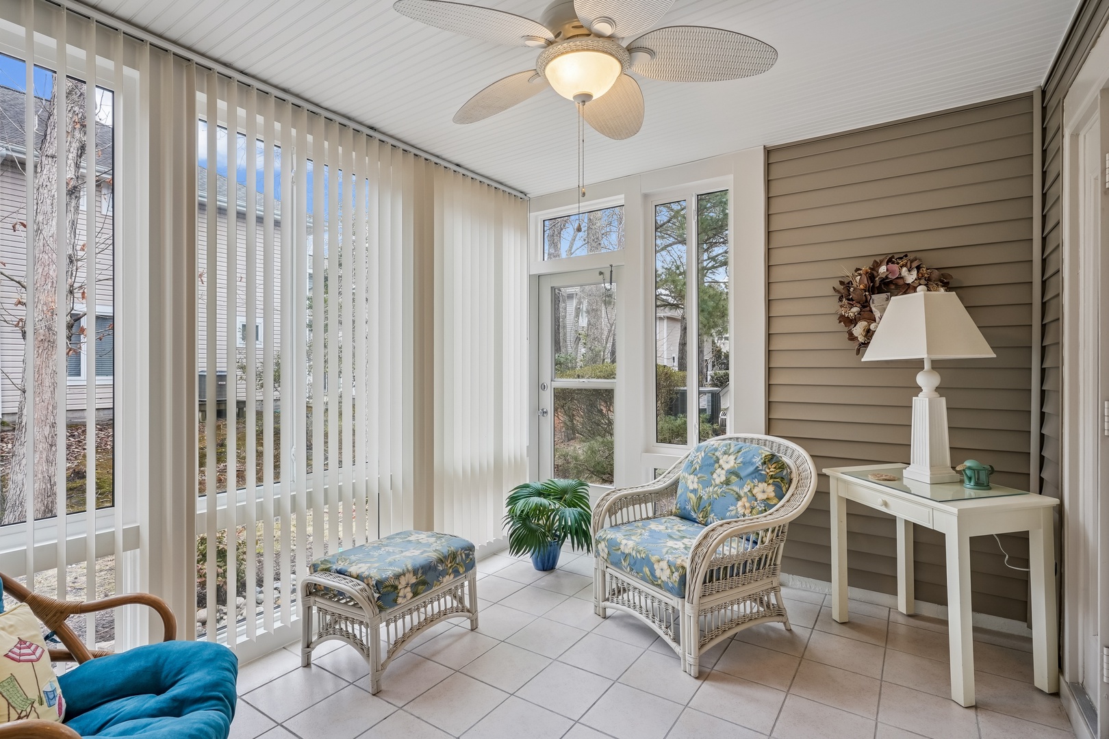 Your bright sunroom features comfortable wicker seating where you can relax with morning coffee while natural light streams through large windows.