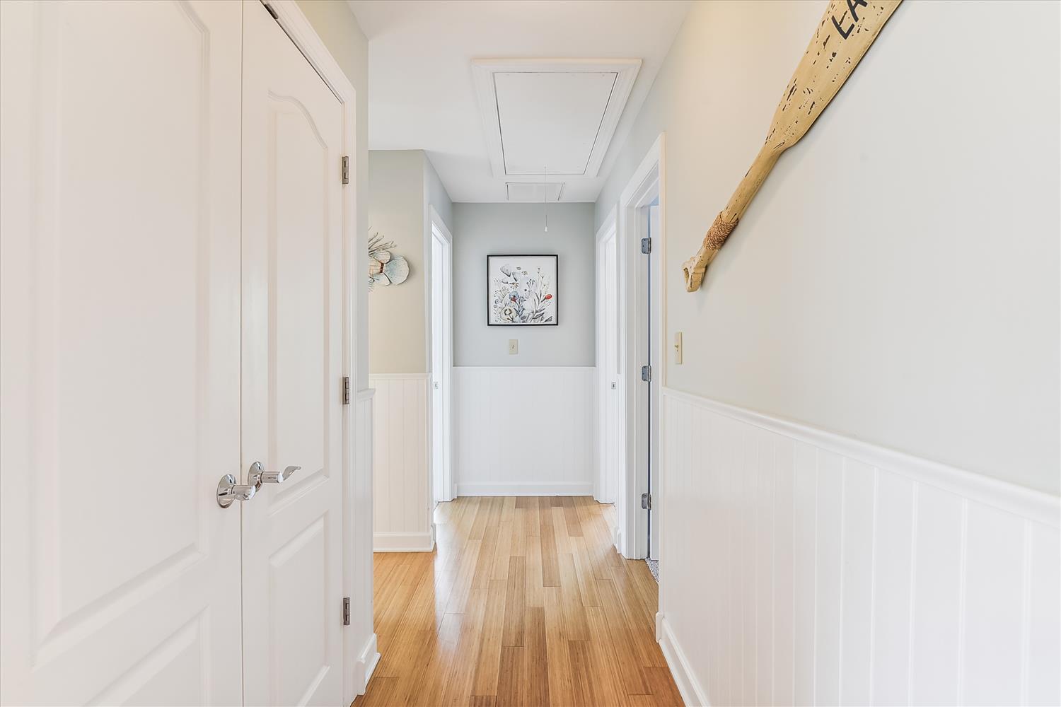 Bright hallway with warm wood floors and coastal-inspired décor connecting your spaces with easy flow and natural light.