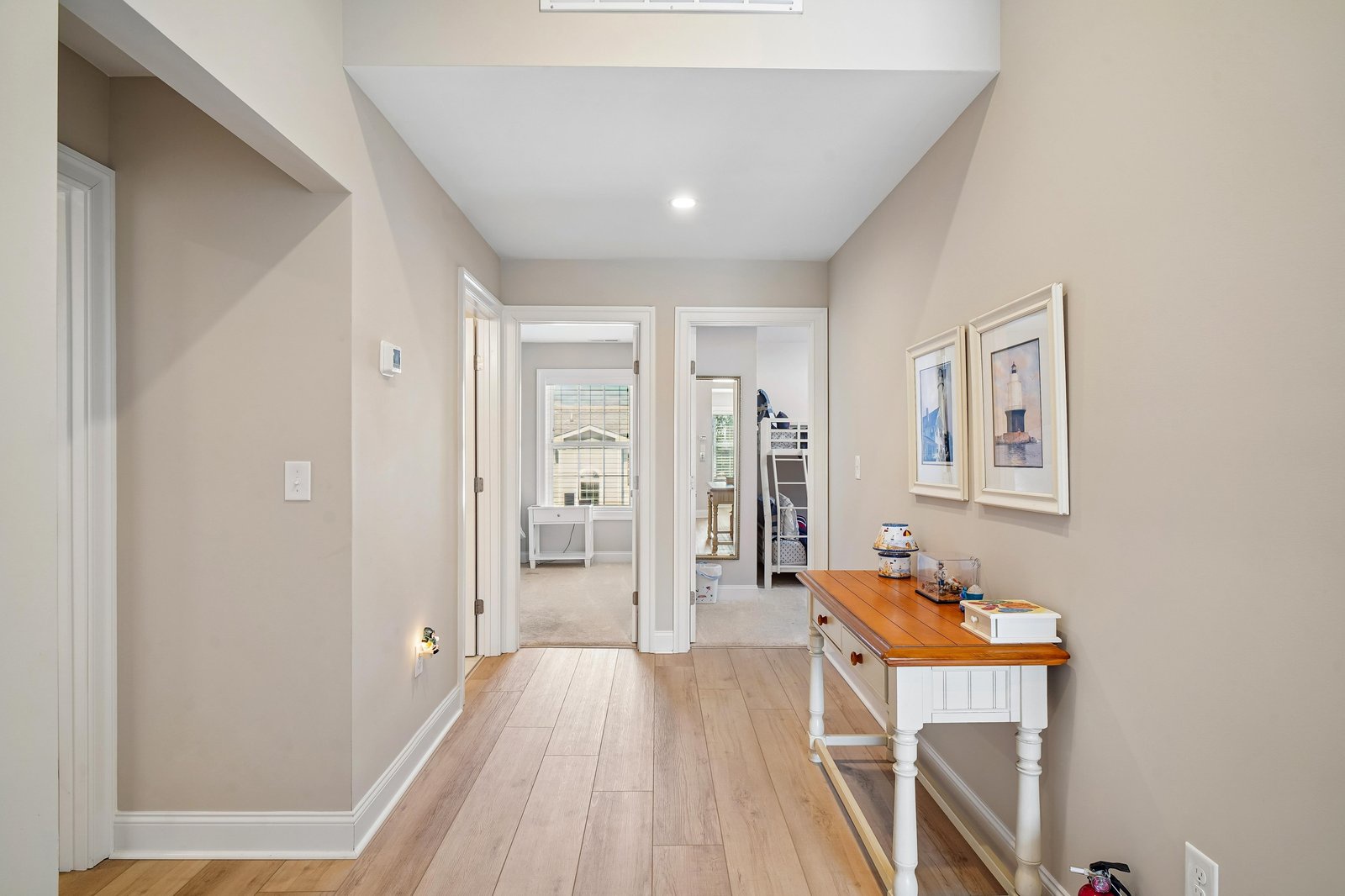 Step into a bright, welcoming hallway with warm wood floors and soft neutral tones that guide you effortlessly between rooms—your perfect retreat starts here.