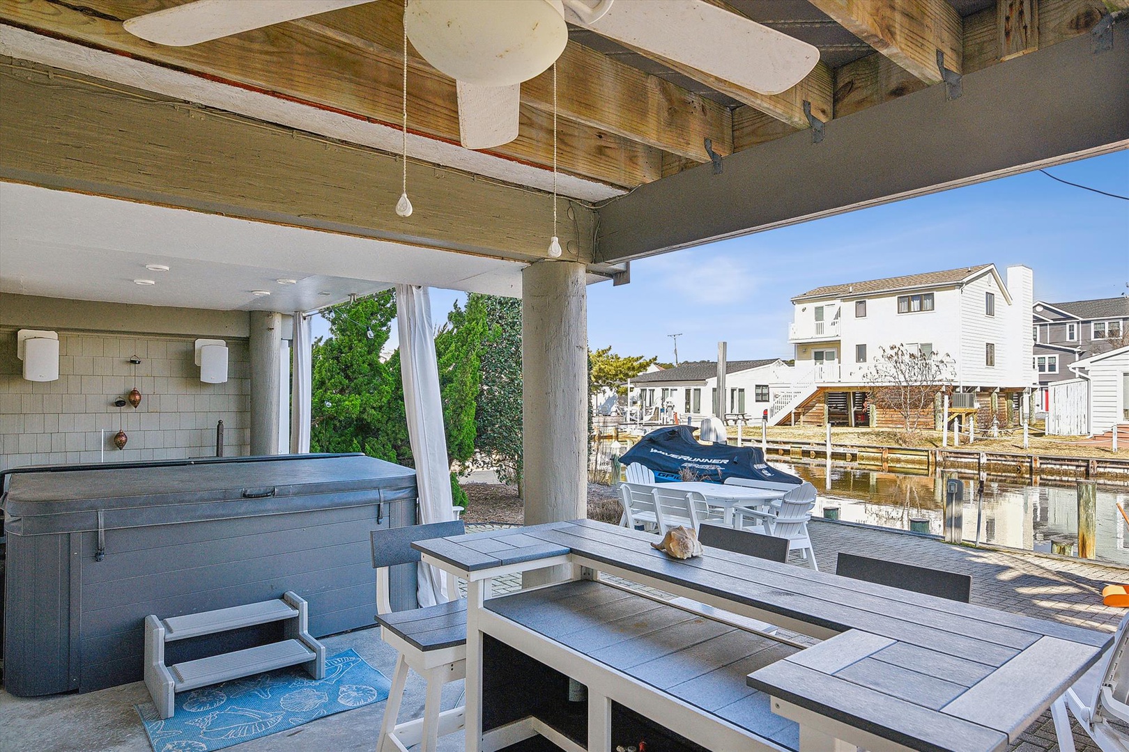 Unwind on your covered deck with hot tub, dining table, and waterfront views—perfect for morning coffee or evening relaxation.