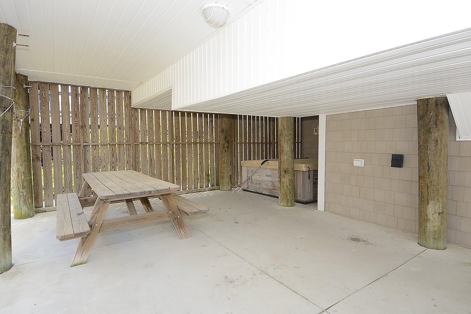 Your private covered patio offers a peaceful retreat with rustic wooden touches and a picnic table perfect for morning coffee or evening relaxation.