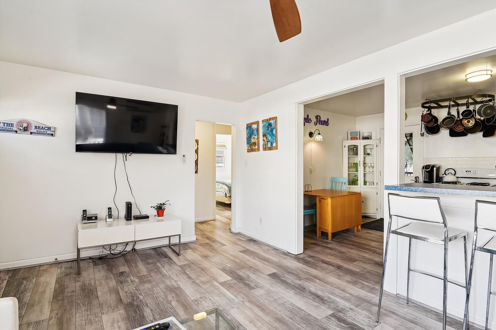 Relax in your open-concept space with a large TV, modern kitchen, and breezy coastal touches—perfect for unwinding after a day at the beach.
