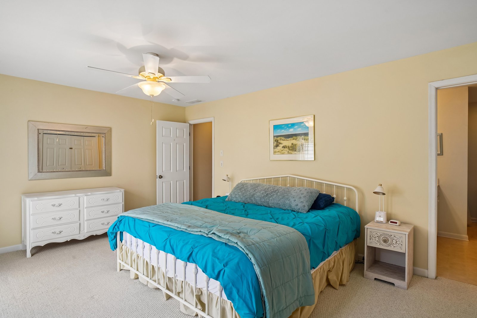Your peaceful bedroom features a comfortable queen bed with soft linens, a ceiling fan for gentle breezes, and ample dresser space to unpack and settle in.