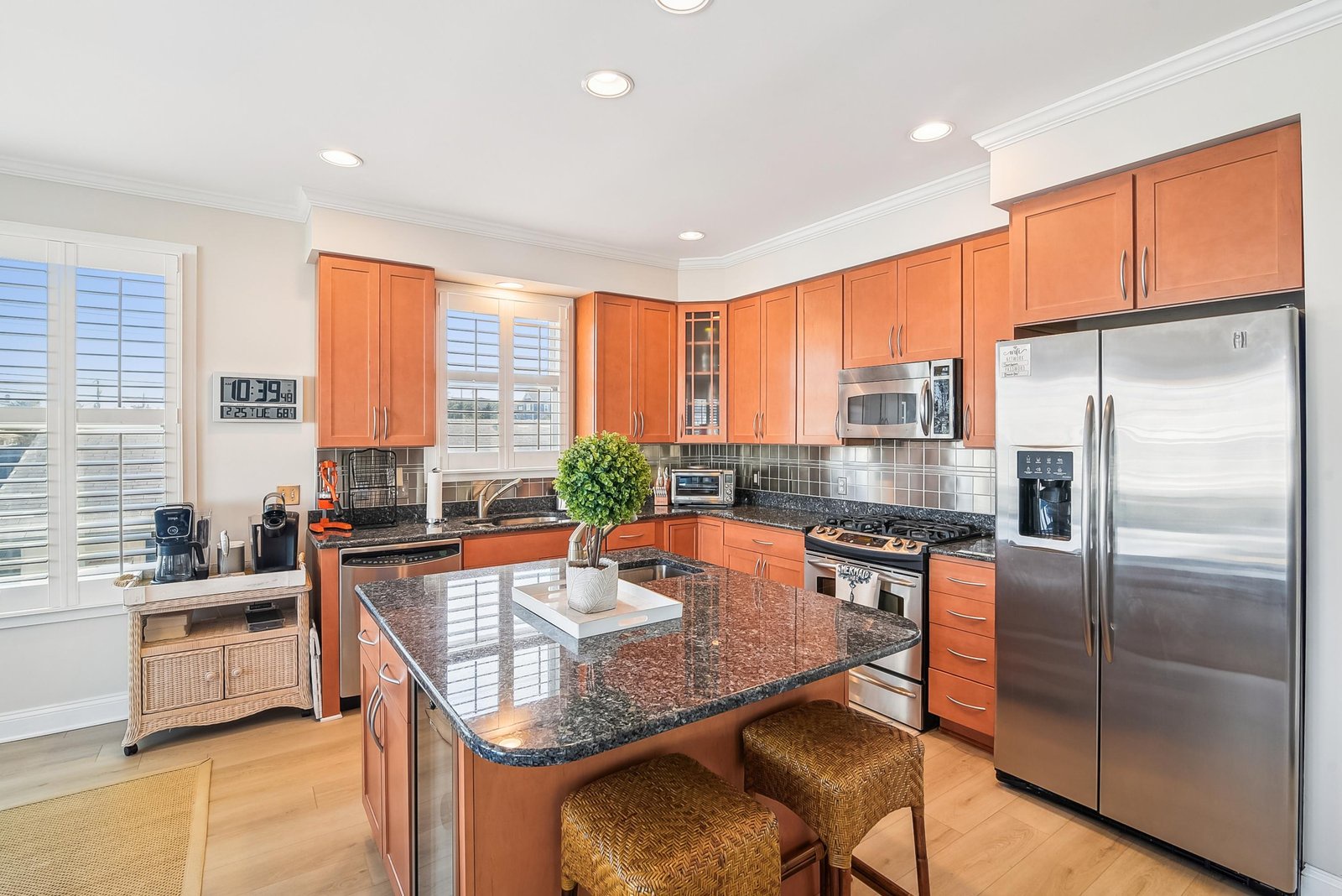 Your gourmet kitchen awaits with gleaming granite counters, stainless steel appliances, and a breakfast bar perfect for morning coffee or quick bites. Warm wood cabinetry and natural light create an inviting space to cook and gather.