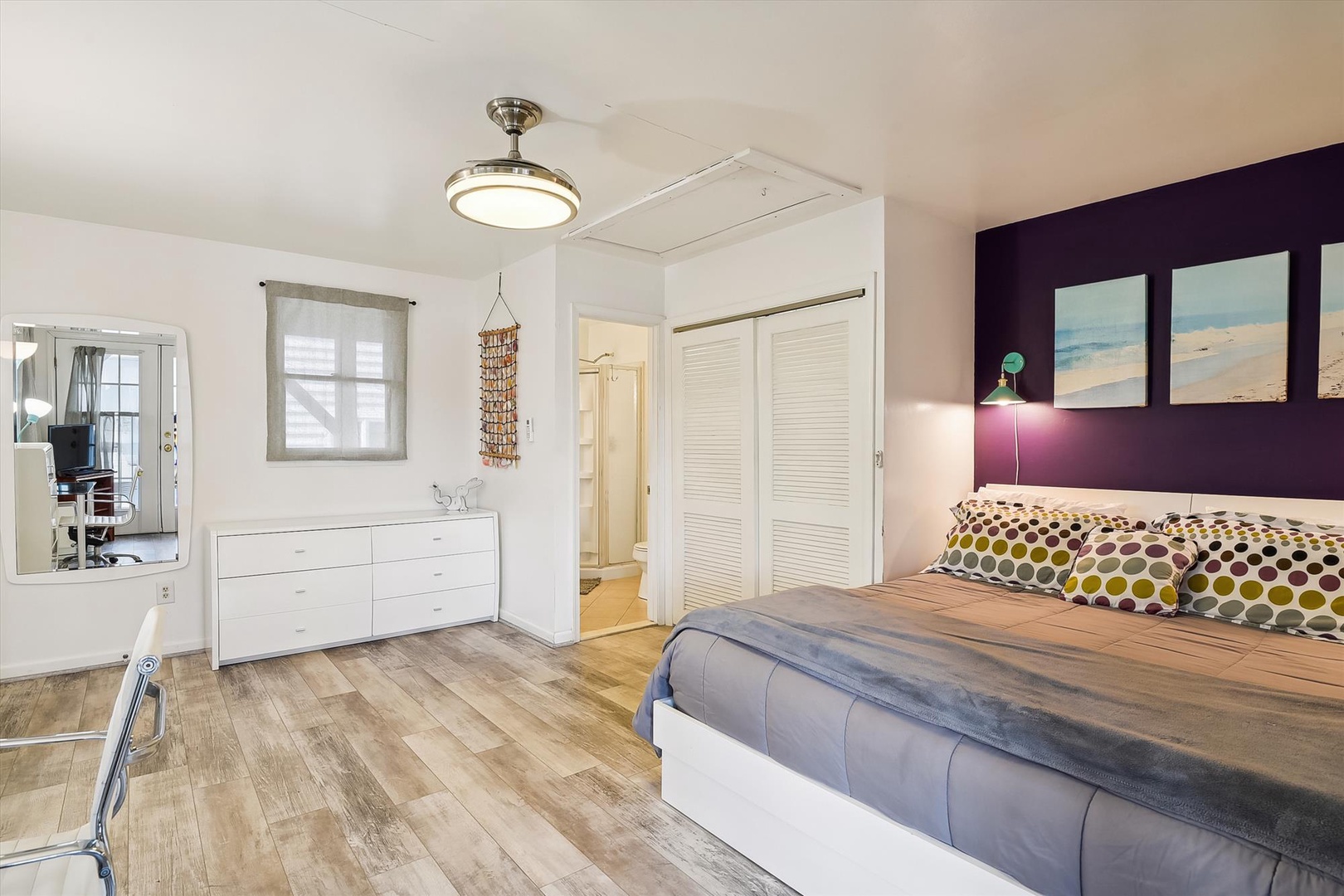 Sink into this airy bedroom where beach artwork sets a coastal mood. Your private closet and dresser keep belongings organized while warm wood floors add charm.