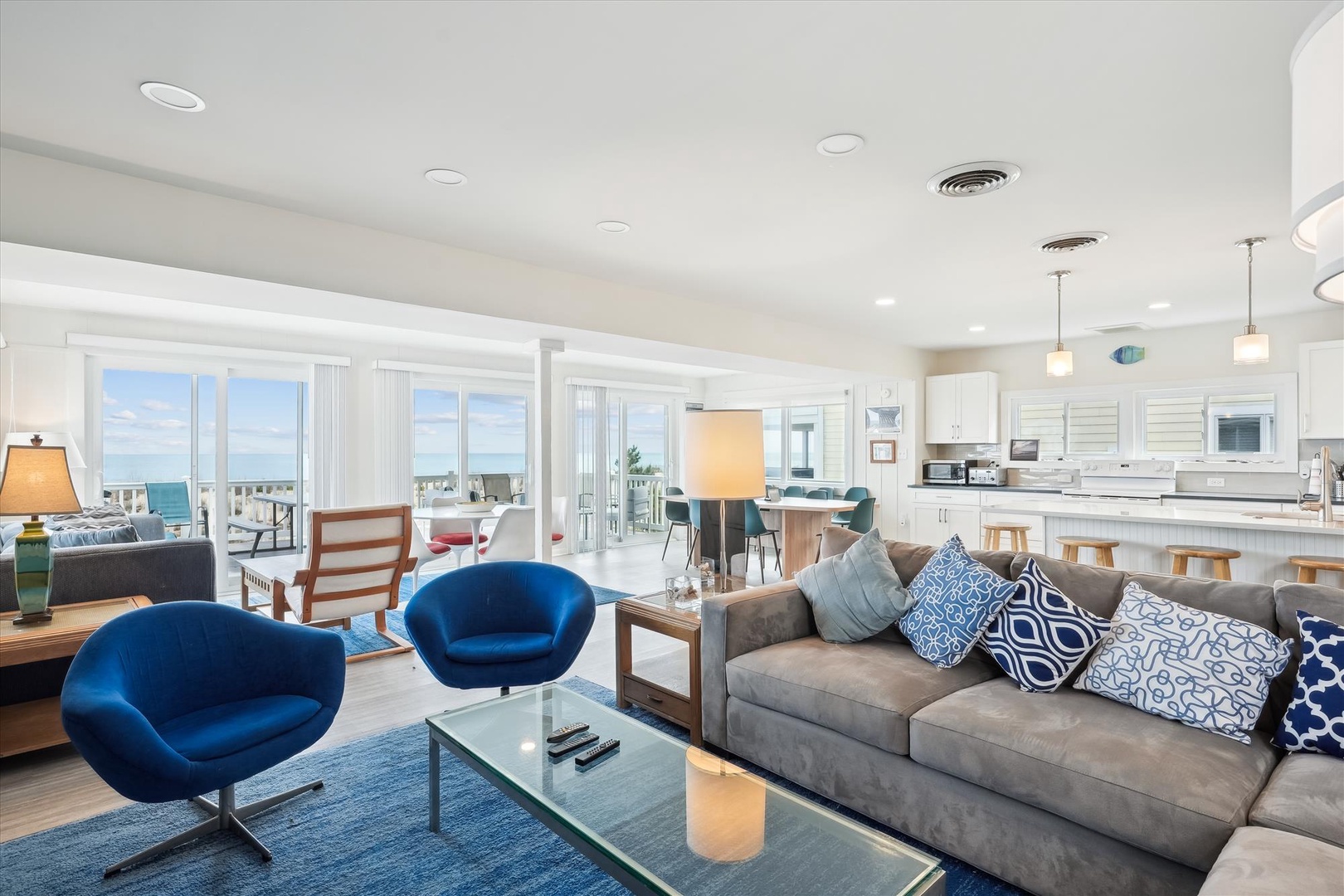 Sink into plush seating while soaking up sweeping ocean views through floor-to-ceiling windows. This bright, open space flows seamlessly from lounge to kitchen, inviting you to gather, relax, and savor every coastal moment.