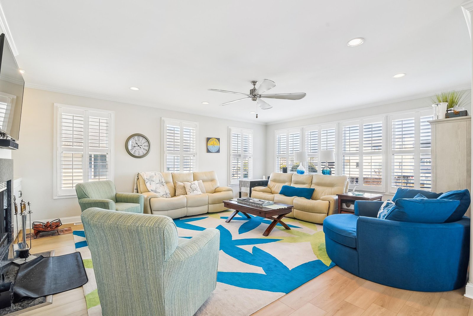 Sink into plush seating beneath the gentle spin of the ceiling fan as sunlight streams through plantation shutters all around. This bright, spacious living room invites you to unwind with friends or family in your home away from home.