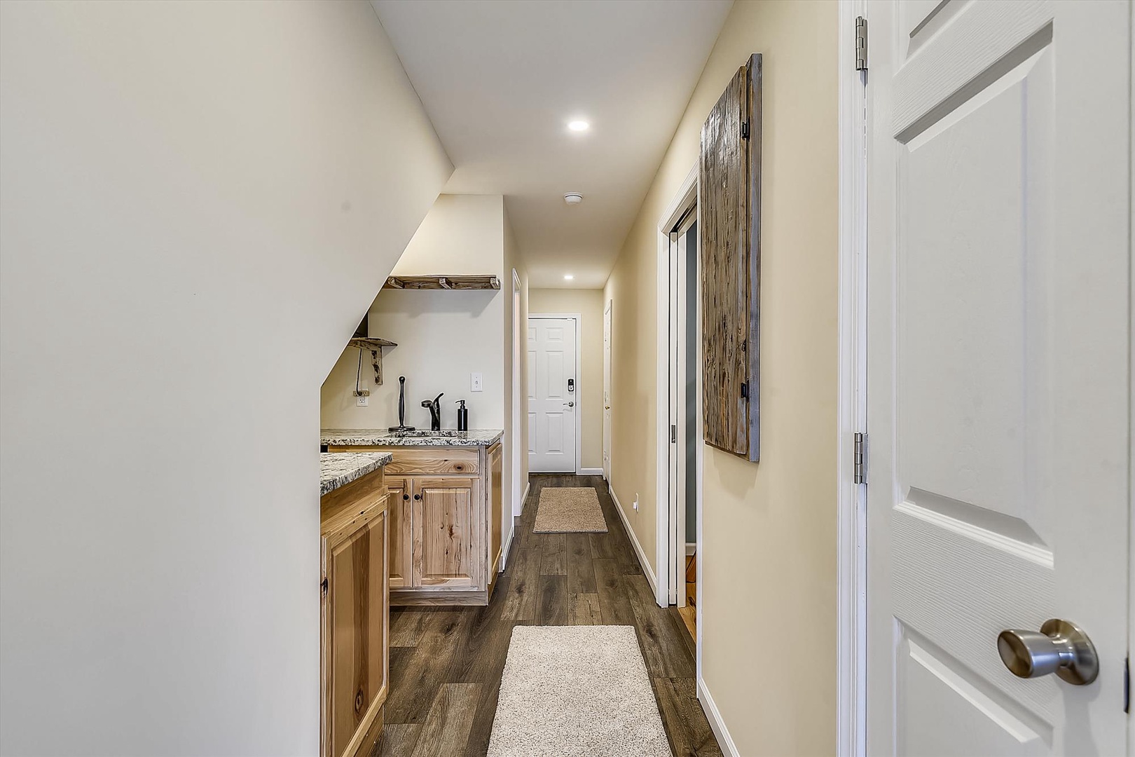 A bright hallway with warm wood cabinetry and modern finishes connects your private spaces, offering everything you need close at hand.