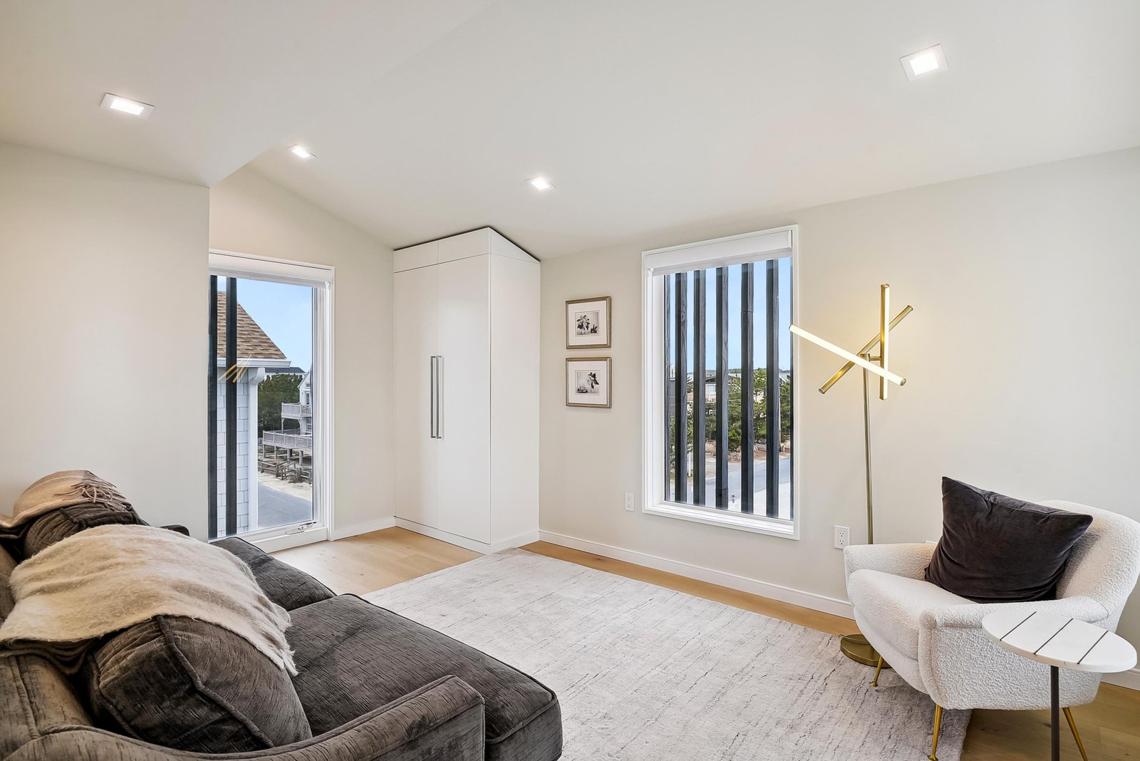 Step into your bright and airy bedroom where sunlight streams through expansive windows and a modern wardrobe keeps your belongings perfectly organized.