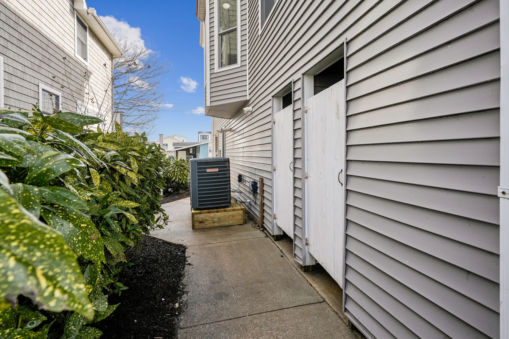 Well-maintained residential building exterior with modern air conditioning and landscaping in a quiet neighborhood setting.