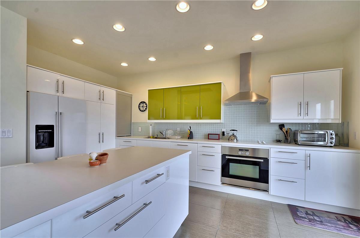 Bright, modern kitchen with sleek white counters and a pop of chartreuse—your culinary command center awaits.