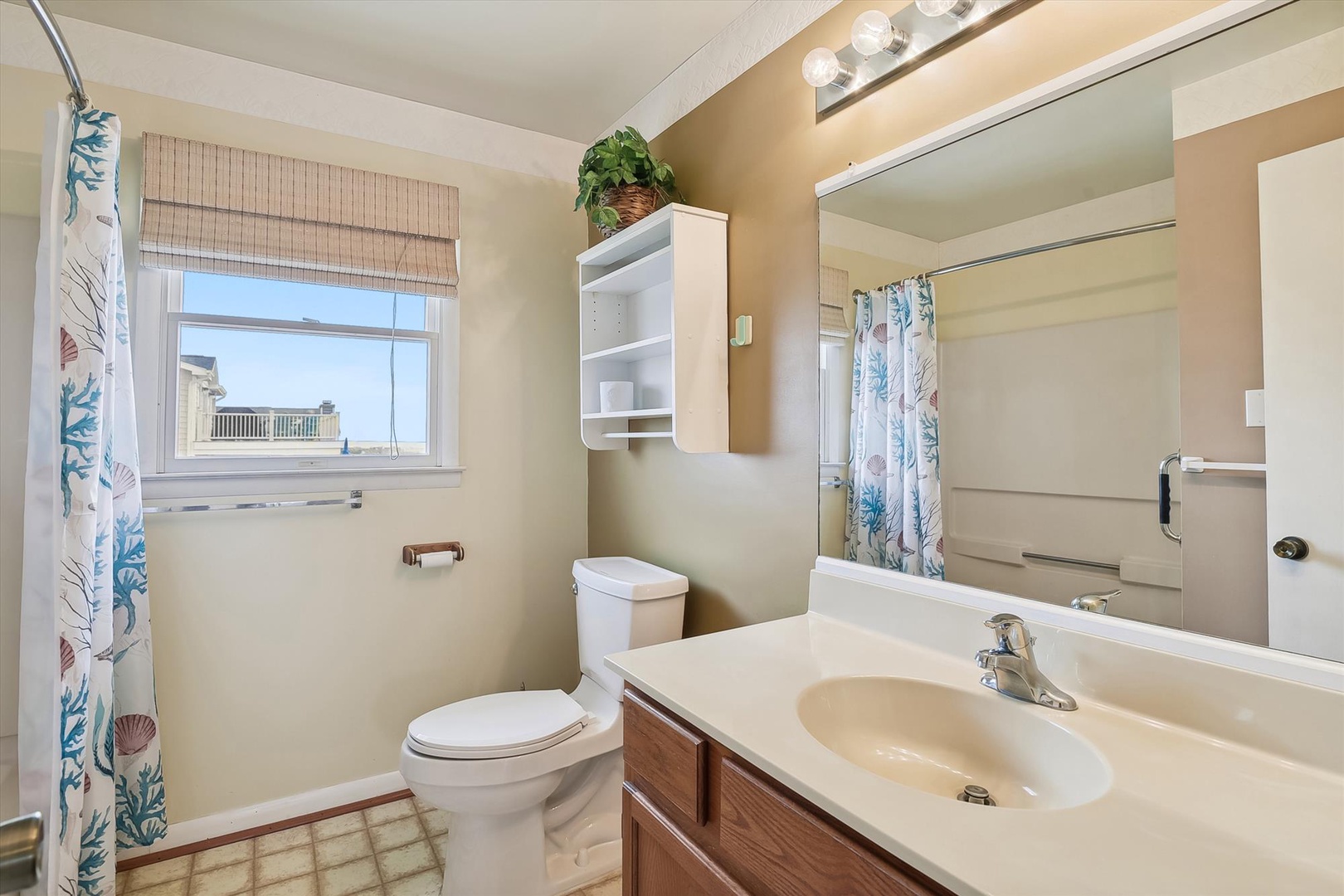 Your private bathroom features coastal-themed touches and all the essentials, with natural light streaming through the window to create a bright, welcoming space for your daily routine.