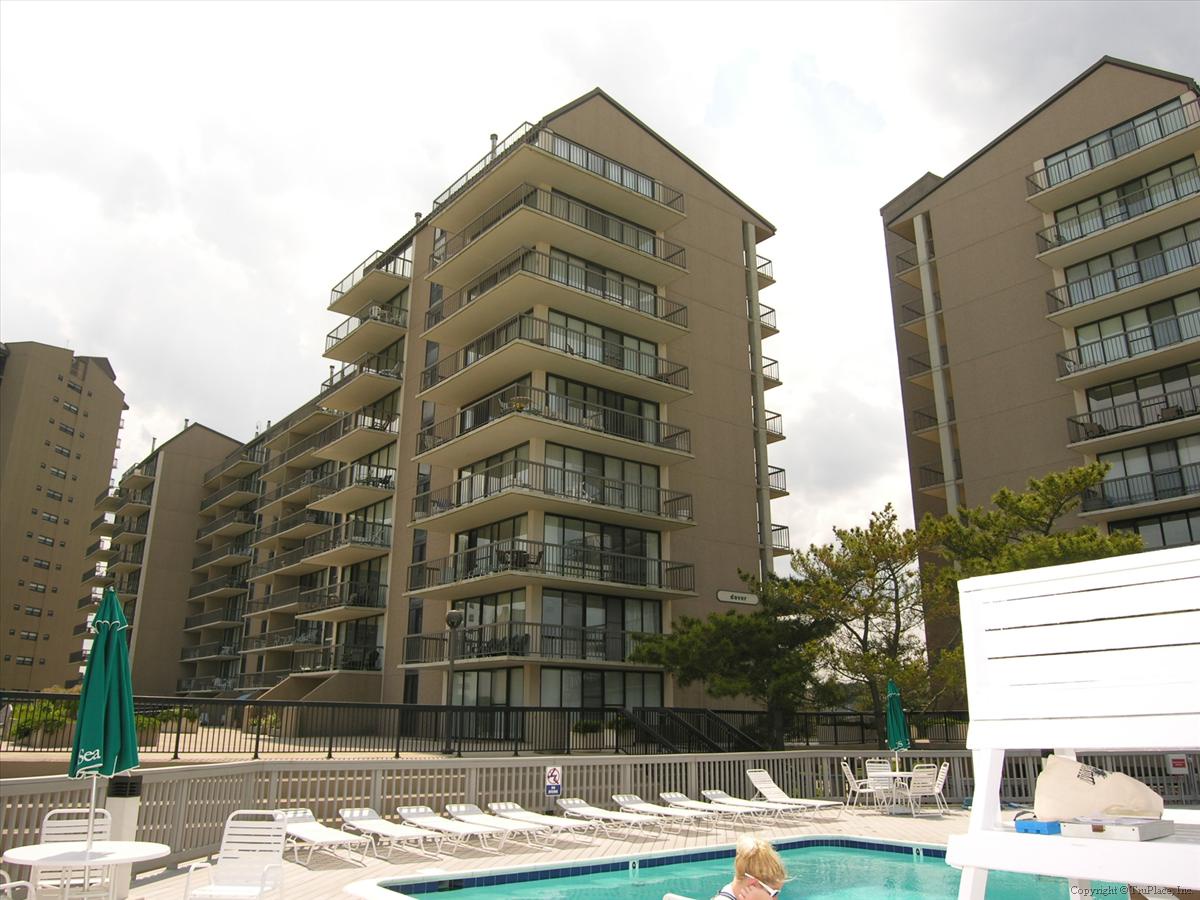 Multi-story beachfront buildings with private balconies overlook the sparkling pool area where you can soak up the sun.