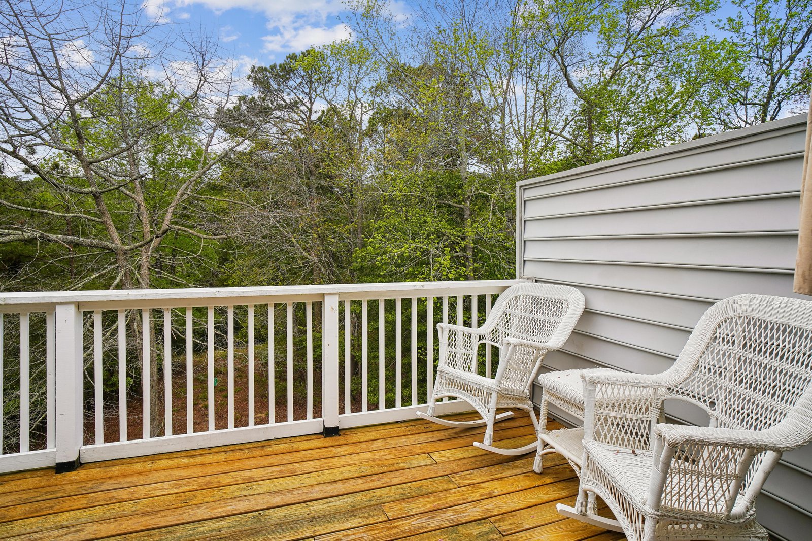 Step out onto your private balcony, where white wicker rockers invite you to relax and soak in the serene treetop views—a peaceful retreat to start or end your day.