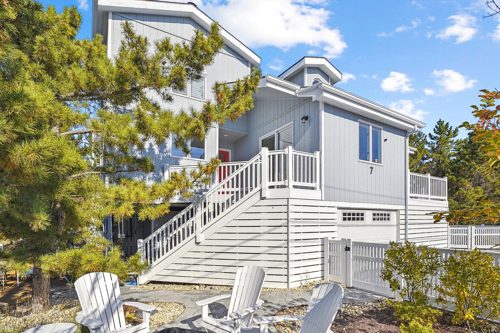 A charming coastal retreat with modern architecture, surrounded by mature pines and thoughtfully landscaped grounds, offering a peaceful setting for your beach vacation.