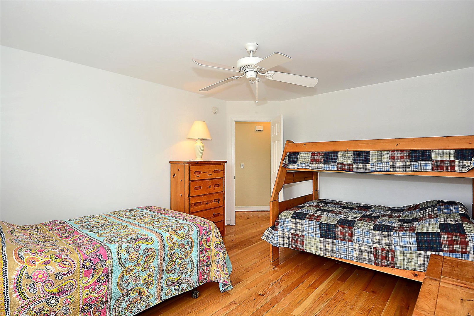 Your bright, spacious bedroom with cheerful quilts, cozy bunk beds, and a gentle ceiling fan to keep you comfortable all night.