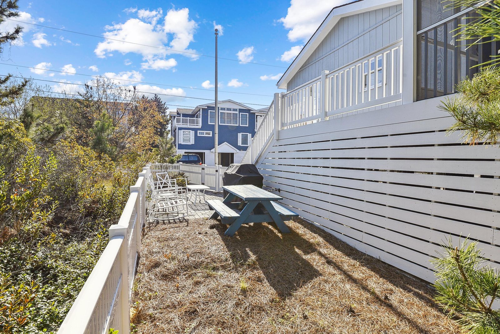 Fenced outdoor space with a picnic table, perfect for morning coffee or casual meals in the fresh coastal air.