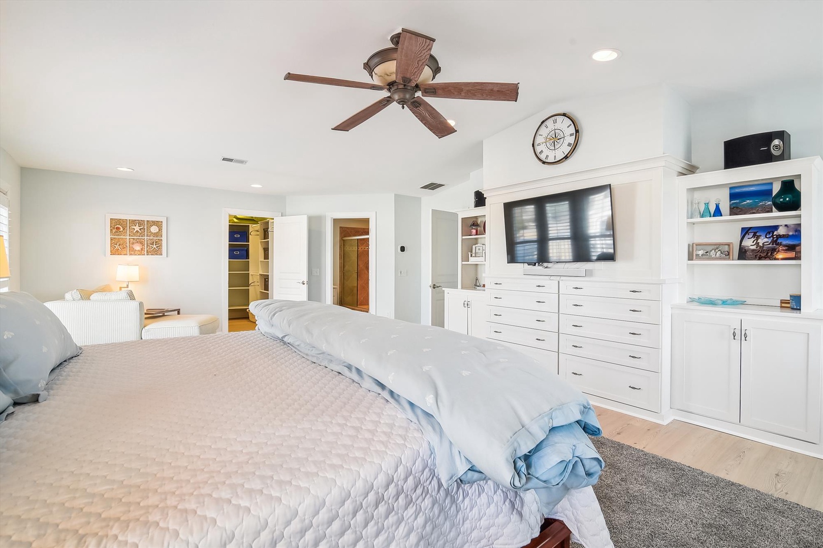 Your spacious master suite features a plush bed, built-in storage, entertainment center, and coastal-inspired décor, plus a ceiling fan to keep you comfortable year-round.
